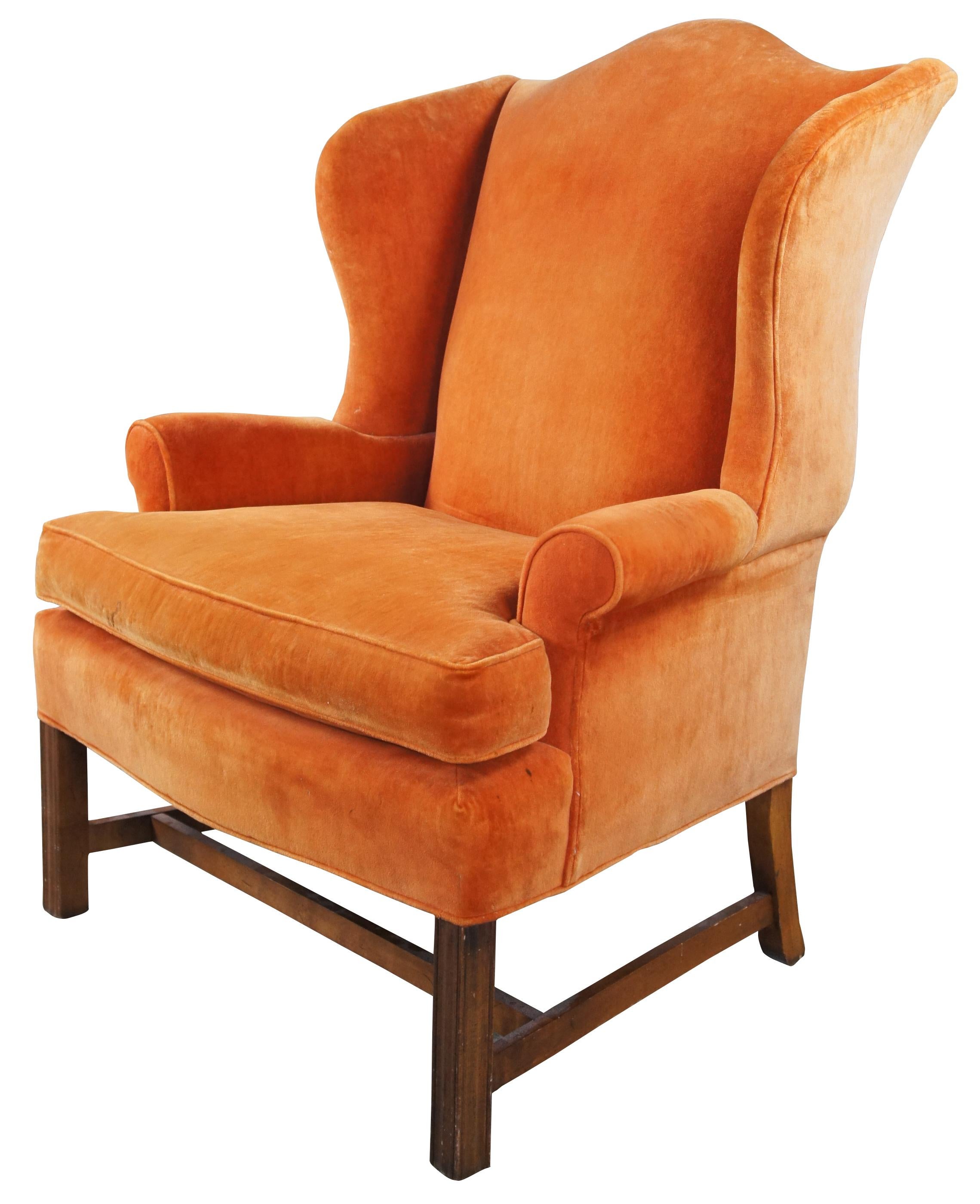 Vintage mid century General Interiors Corporation wingback armchair featuring serpentine form with orange velvet upholstery.
m