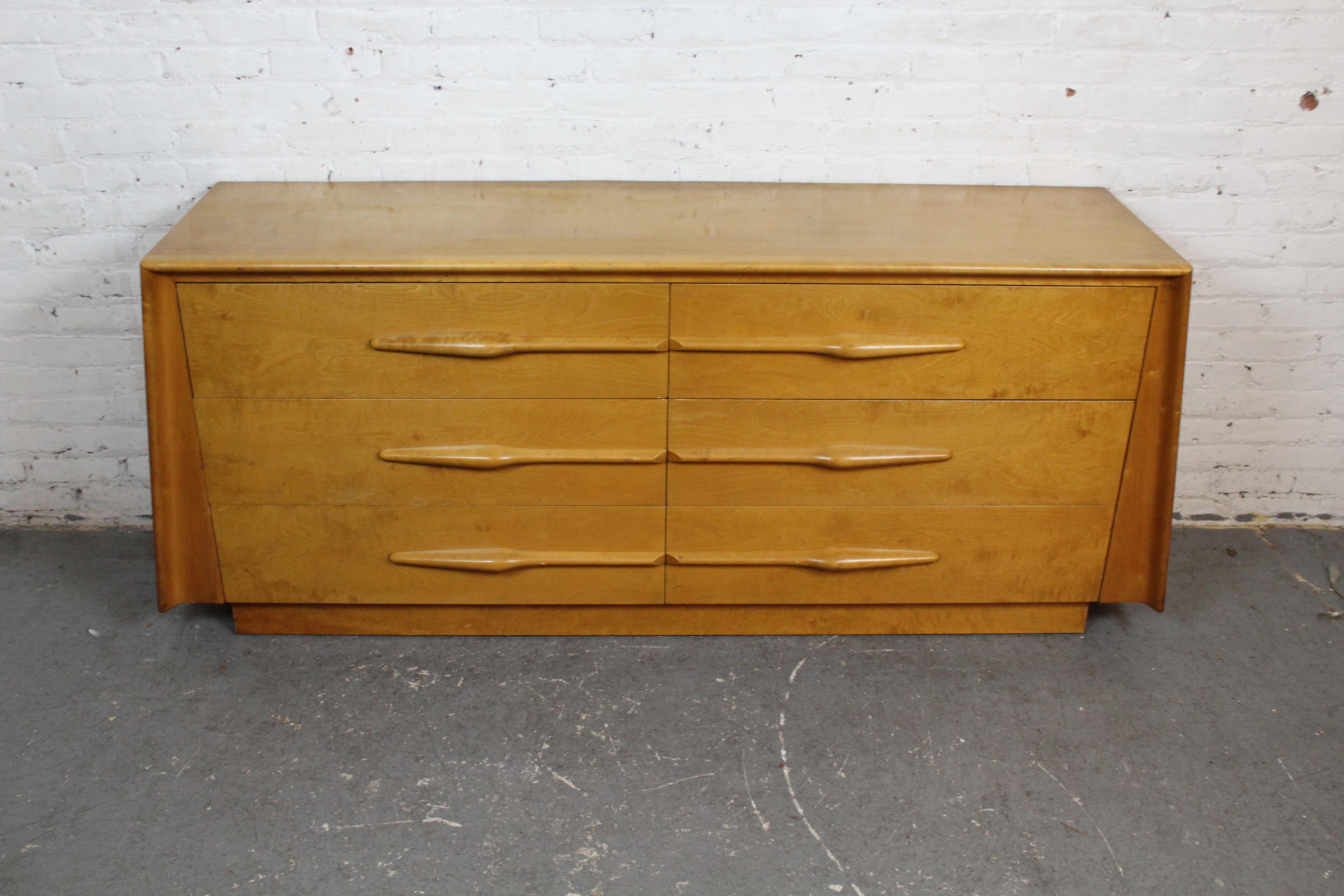 From one of the most visionary designers in Mid-20th Century Modern furniture, this truly exceptional dresser by Edmond J. Spence (1911-1986) is sure to stand out in any room. Manufactured in Sweden for America’s Modernage brand, this striking piece