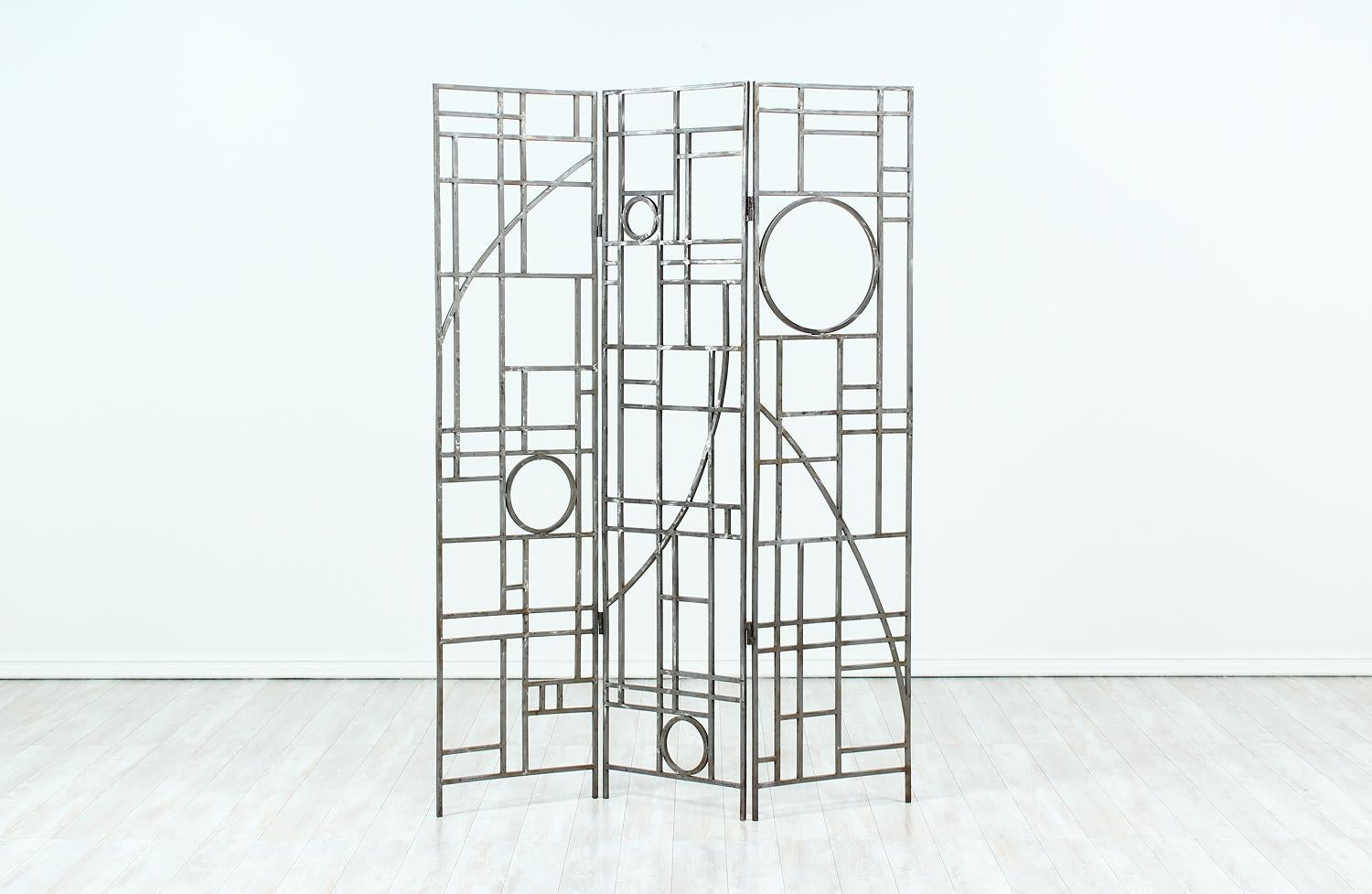 Post-Modern folding room divider designed by Robert Sonneman for George Kovacs in the United States circa 1990s. This functional design features a quality crafted brushed metal frame adorned with geometric shapes that reflect a mix of Art Deco and