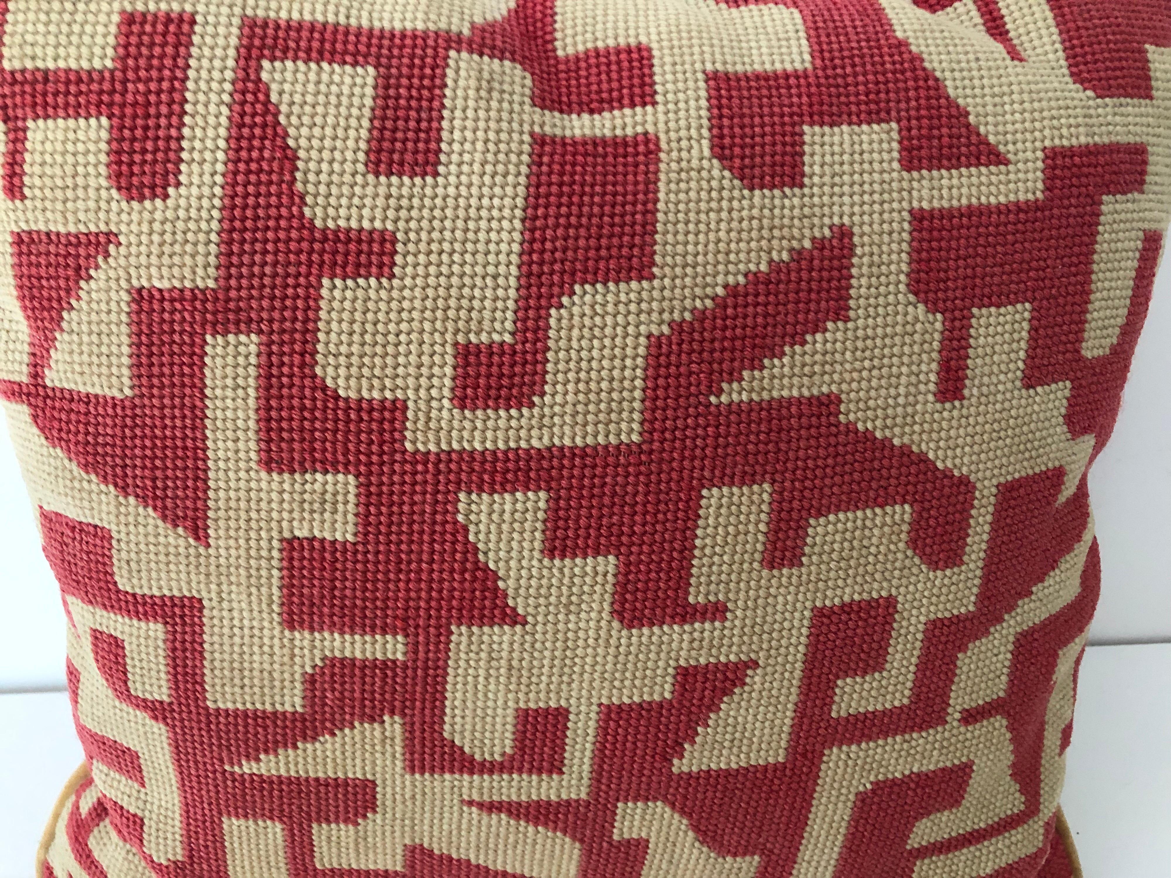 A handmade midcentury geometric needlepoint pillow with tan velvet back. Tones of deep pink/rose and off white. Two associated pillows also available.