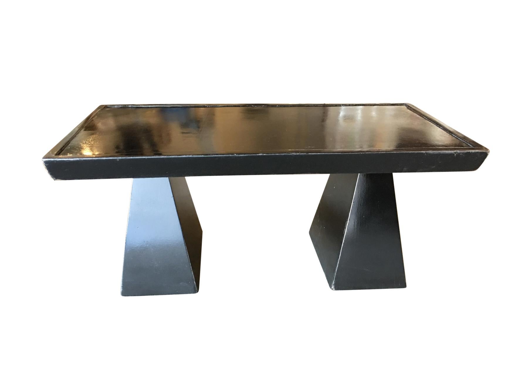 A rare find from the 1950s, this original black lacquer coffee table boasts a Cubist-inspired geometric design. Crafted by renowned designer Gail Fury, its sculptural form and lipped tabletop exemplify mid-century elegance. A unique piece blending