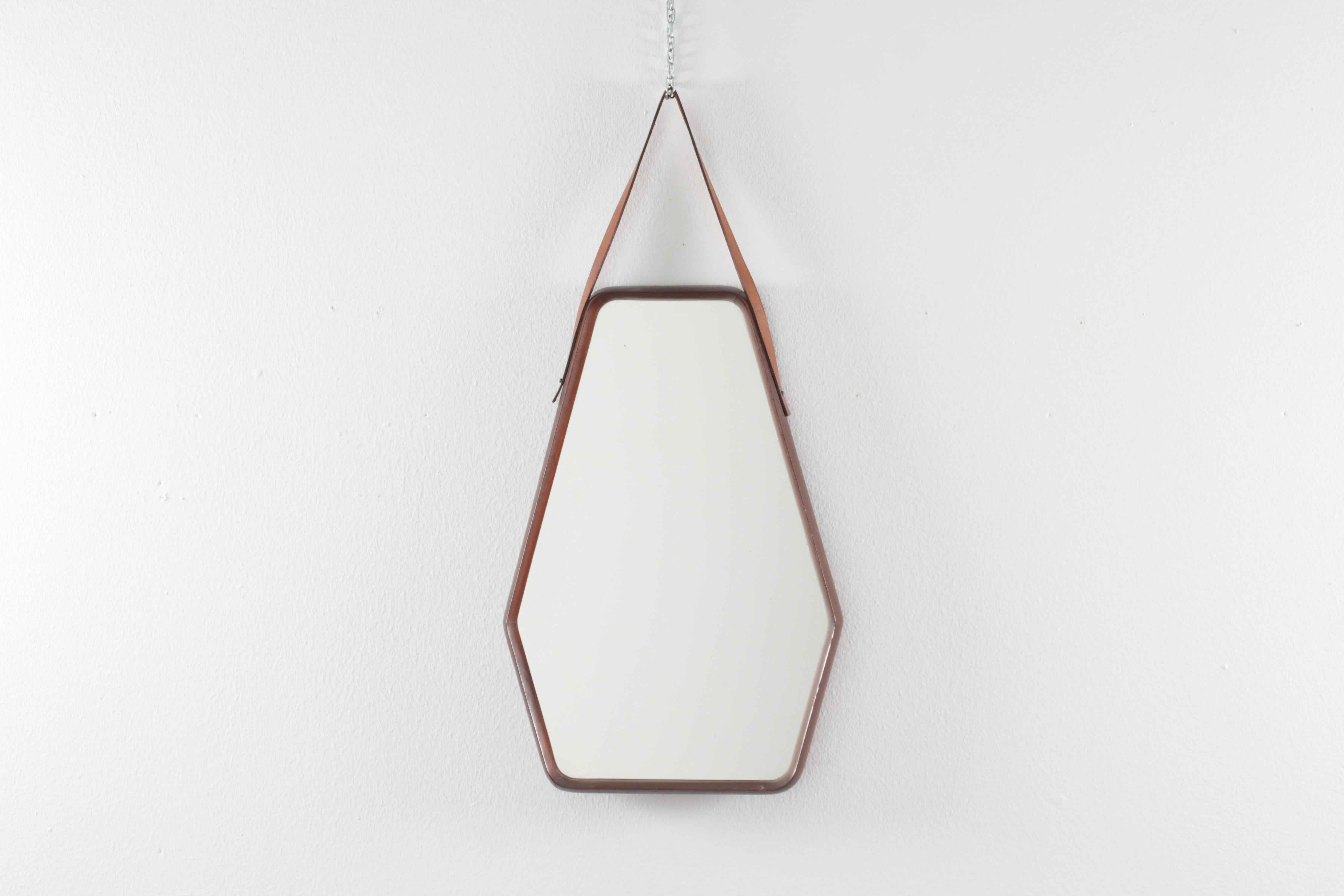 Very original wall mirror with a geometric shape with a thick curved wooden frame and leather band for hanging. Italian production from the 1960s
Wear consistent with age and use.