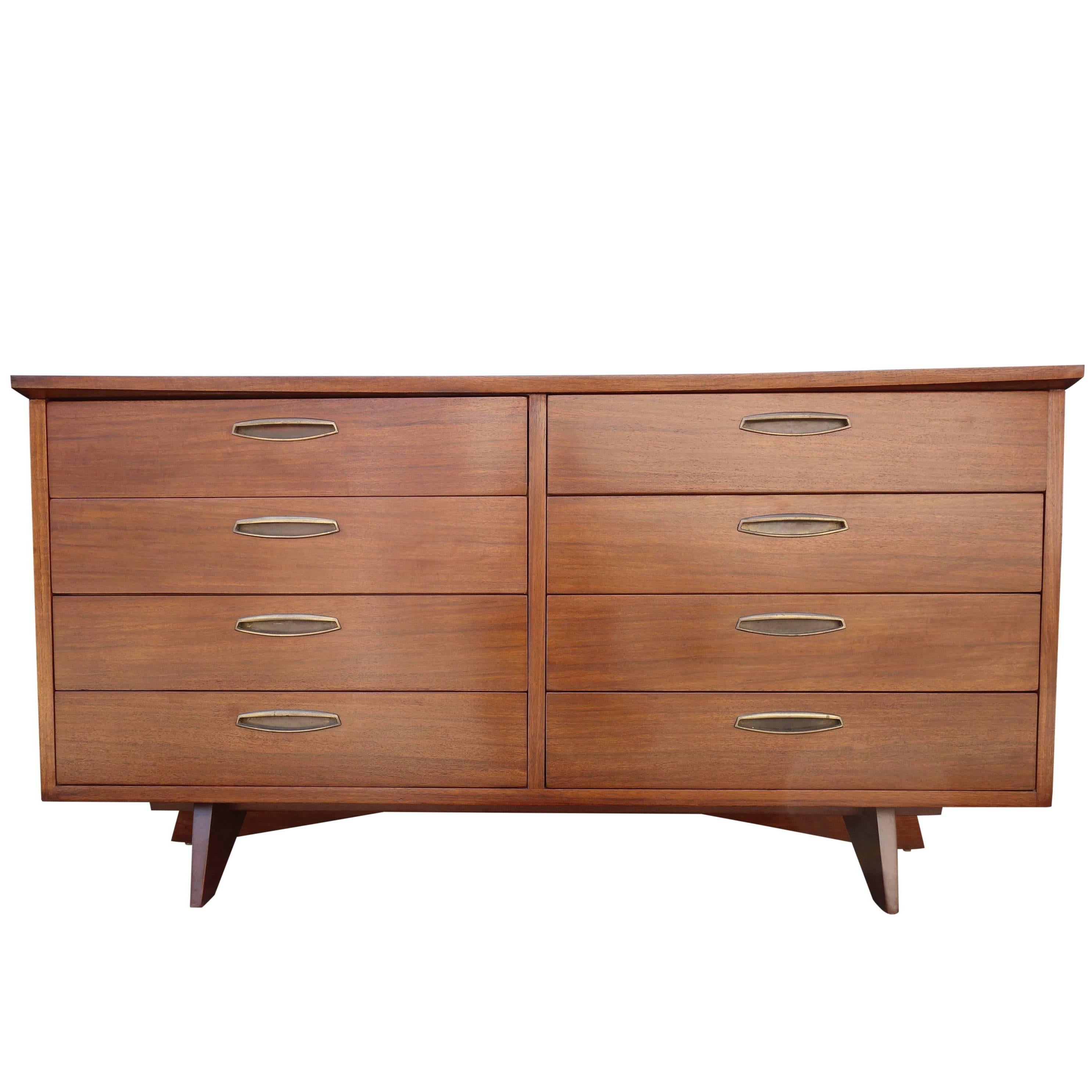 For your consideration is this incredible midcentury eight-drawer cabinet designed by George Nakashima. This case piece rests on a sculptural base featuring brass pulls in original condition. The cabinet has been finished like new while retaining