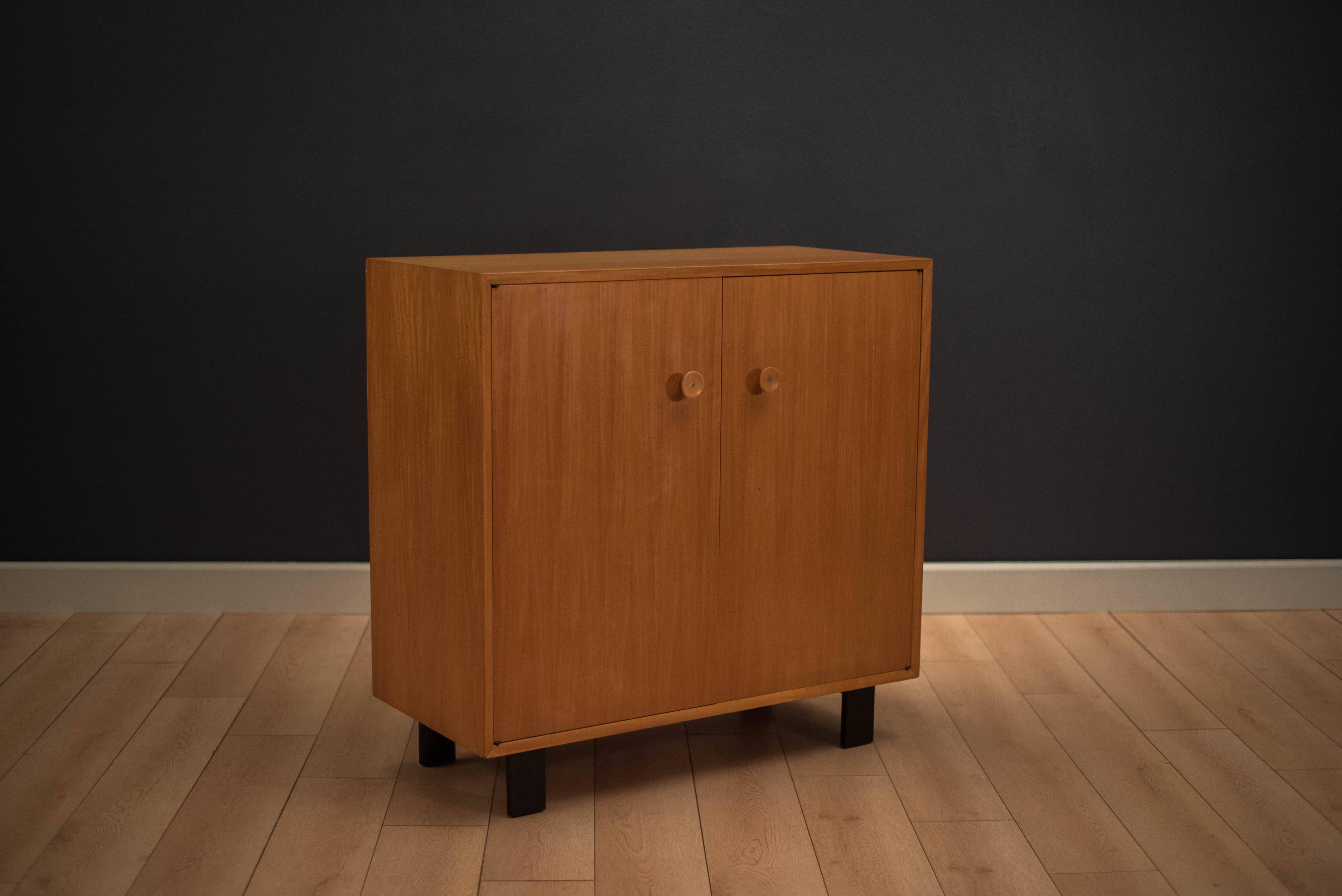 Vintage two-piece basic cabinet series designed by George Nelson for Herman Miller in mahogany. This original piece features the early cupcake pull design and is equipped with plenty of storage and adjustable shelving. Includes top basic cabinet
