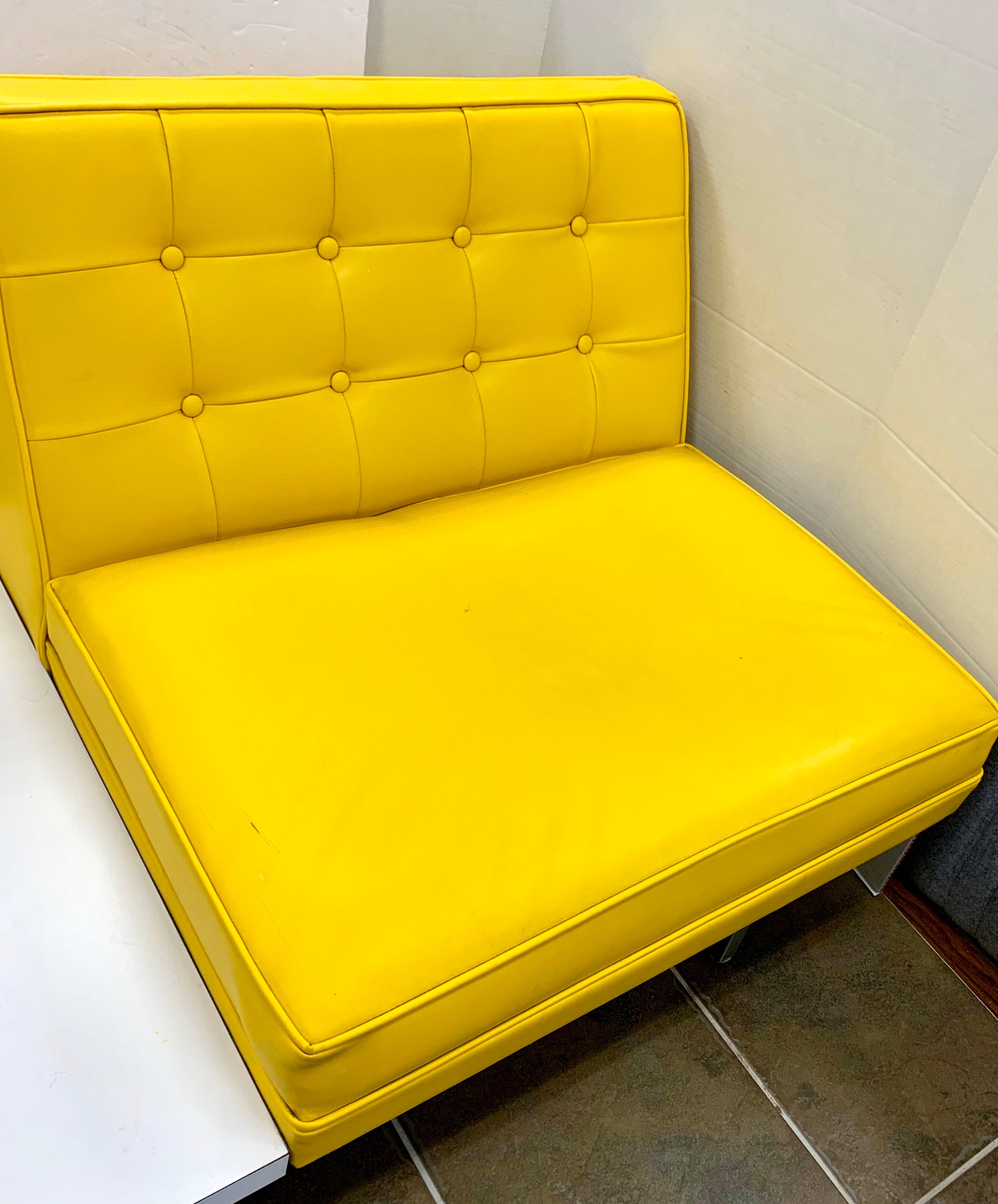 Elegant and iconic midcentury signed living room loveseat designed by George Nelson for Herman Miller. It features original banana yellow vinyl upholstery which is ultra rare and coveted.
The frame is made of chrome steel. The seat has an attached