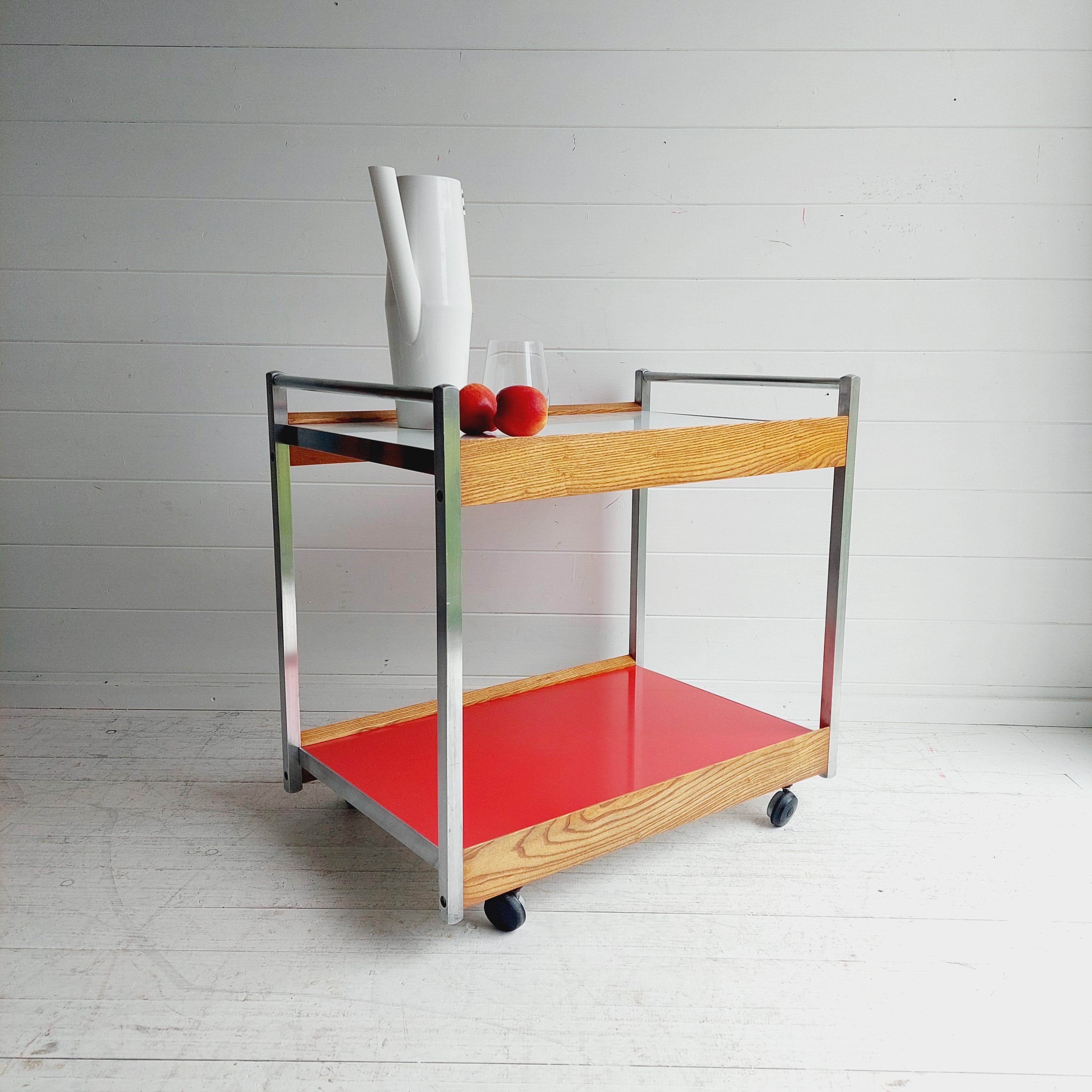 2 tiered Bar or serving cart, circa early 1960s. 
George Nelson for Herman Miller Style

This all original seldom seen example has a aluminum frame  oak accents and white and red Formica tops all in for casters.
The oak frame has a lovely brain