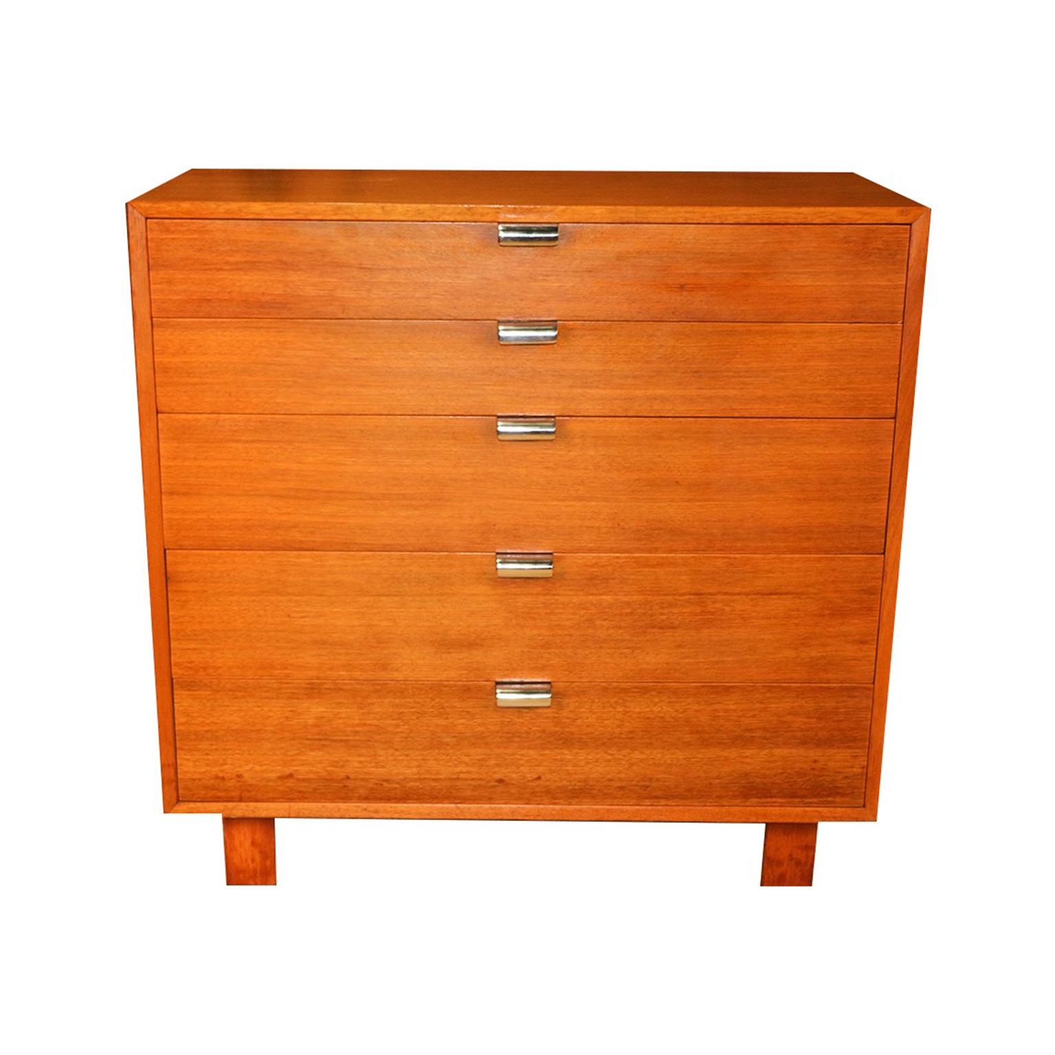Iconic and classic Mid-Century Modern dresser designed by George Nelson for the Herman Miller Primavera line, circa 1950s. Featuring a gorgeous walnut wood dresser with five spacious dovetailed drawers adorned with original striking brushed polished