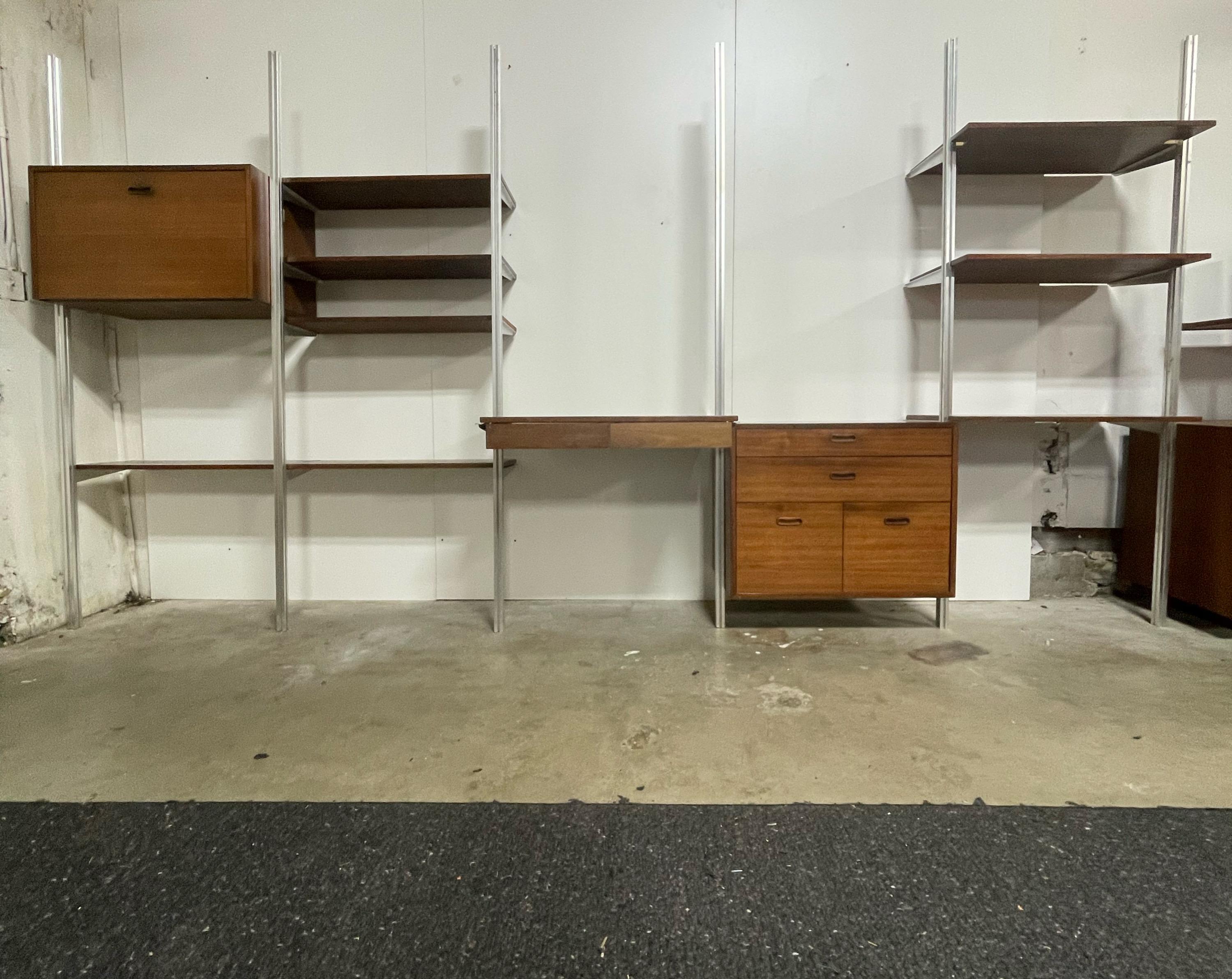 Incredible mid century tension rod wall unit. Designed by the legendary George Nelson. The Omni Unit. (It does have the Omni stamp inside the cabinet) 5 bays total. This unit offers 8 shelves, 1 desk with 2 drawers that slide with ease, a flip down