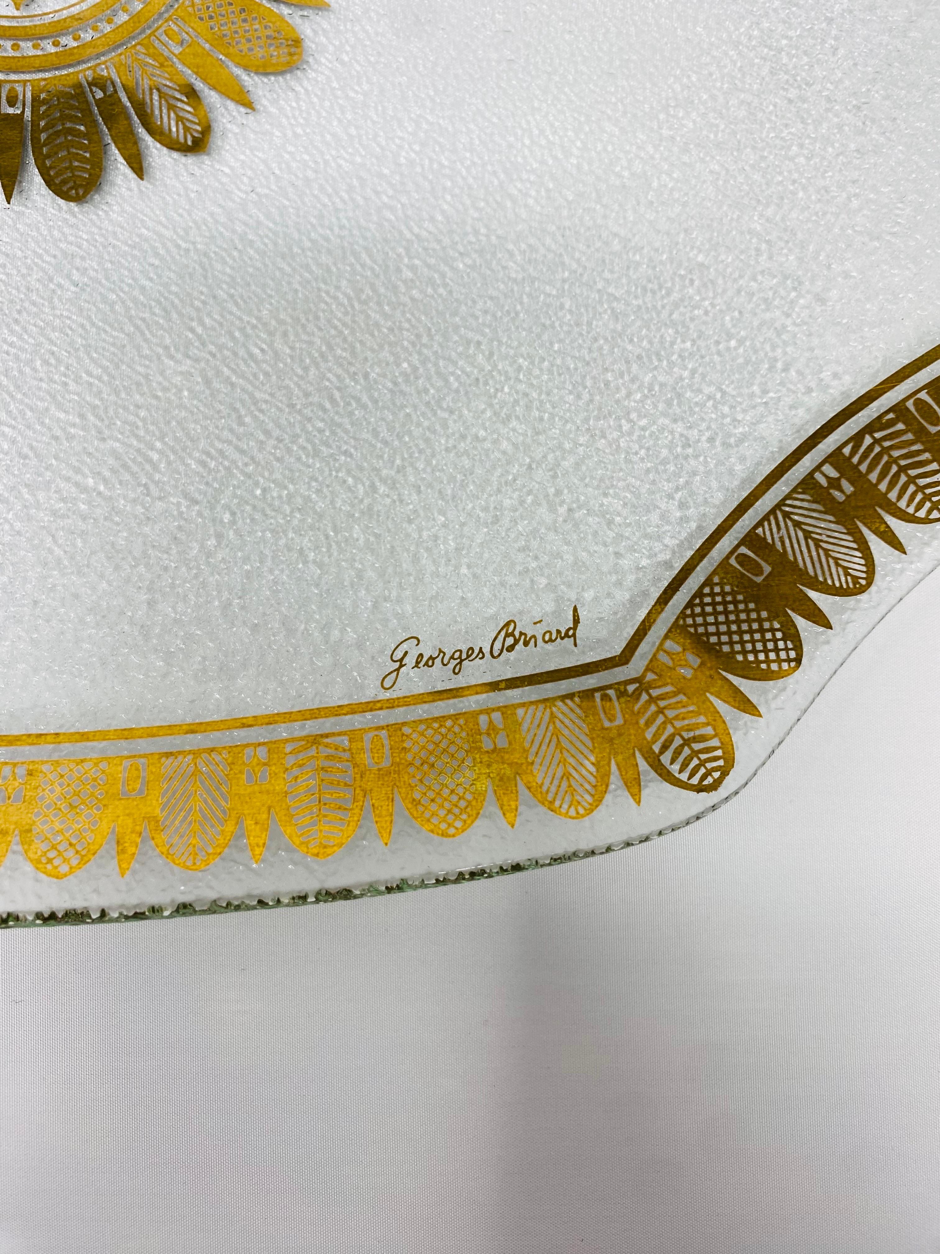 
Preciosa bandeja de cristal diseñada por Georges Briard.  Esta bandeja tiene una superficie de cristal texturizado con un diseño de hojas doradas (sunbursst) y un borde decorativo. Una increíble adición a tu colección y un elegante acento para tus