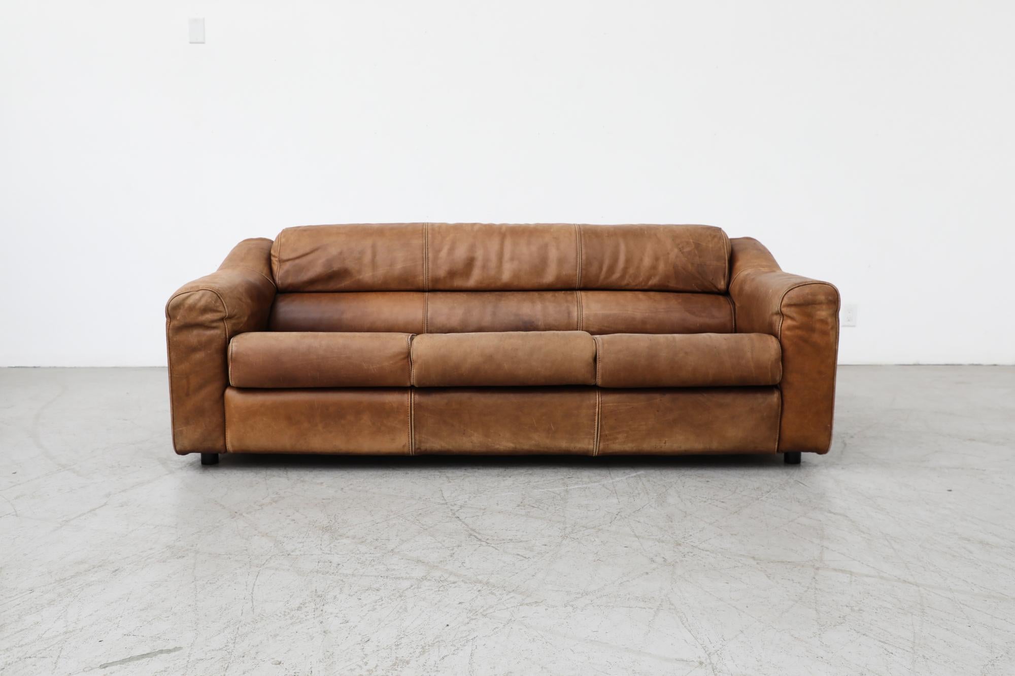 Midcentury large leather three seater sofa with beautiful patina. In the style of Montis designer Gerard van den Berg. In original condition with heavy visible wear including scratching and sun fading. Wear is consistent with its age and use.