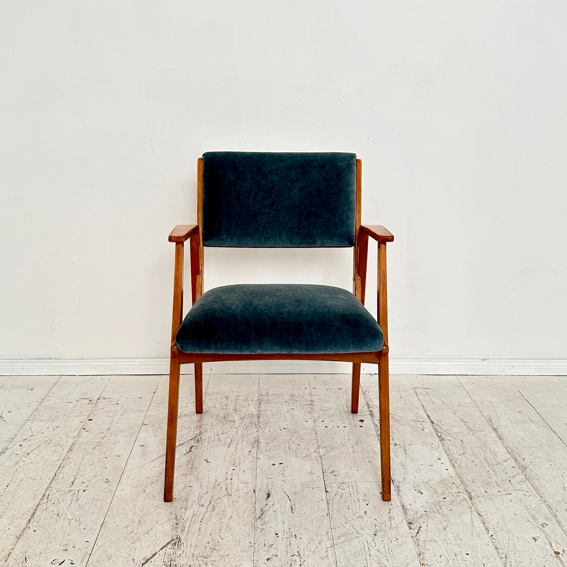 Dieser deutsche Sessel aus der Mitte des Jahrhunderts, hergestellt um 1950, ist eine zeitlose Verkörperung von elegantem Design und dauerhaftem Komfort. 
Der Stuhl besteht aus einem robusten Buchenholzrahmen, der die tadellose Handwerkskunst der