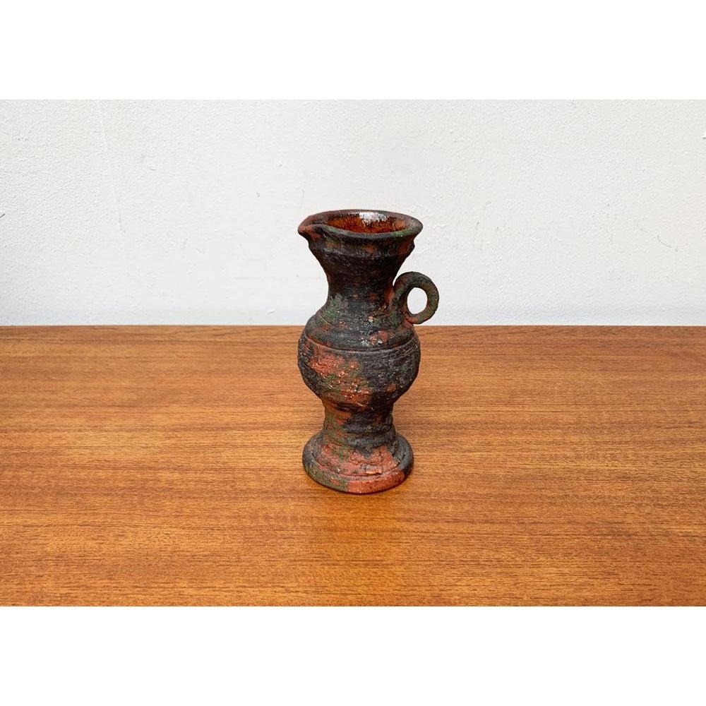 Mid-Century German Brutalist Carafe Vase in the style of Gerhard Liebenthron, 1960s, in None conditions. Designed 1960 to 1969

Additional information:
Materials: Ceramic
Color: Brown
Styles: Brutalist, Mid-Century Modern
Country of Origin: