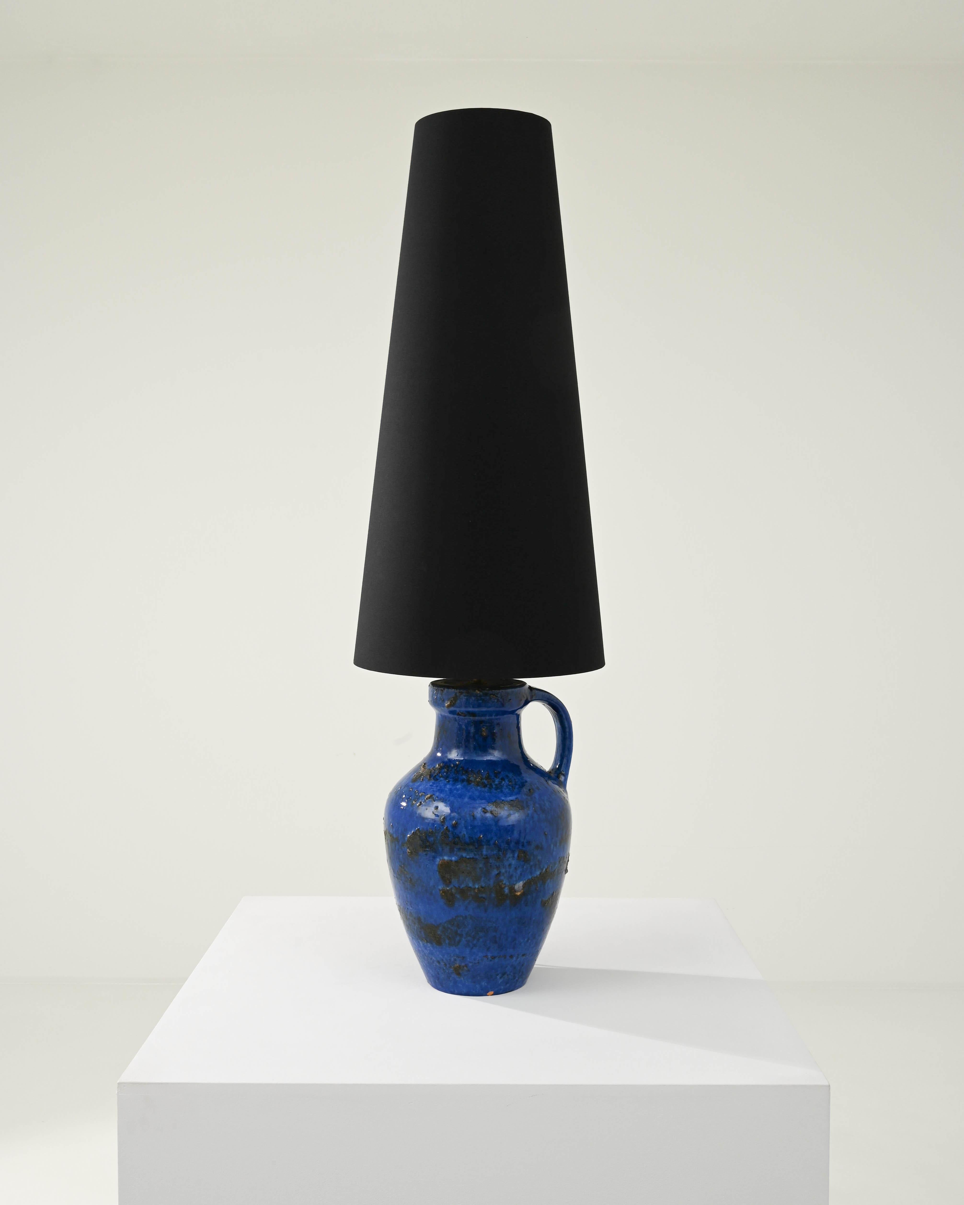 An exceptional find to inspire your collection. Designed in 1960s Germany, this distinctive vase has been adapted into a beautiful table lamp; the tall black lampshade is supported by a brass bulb socket. The fabric shade compliments the beautiful