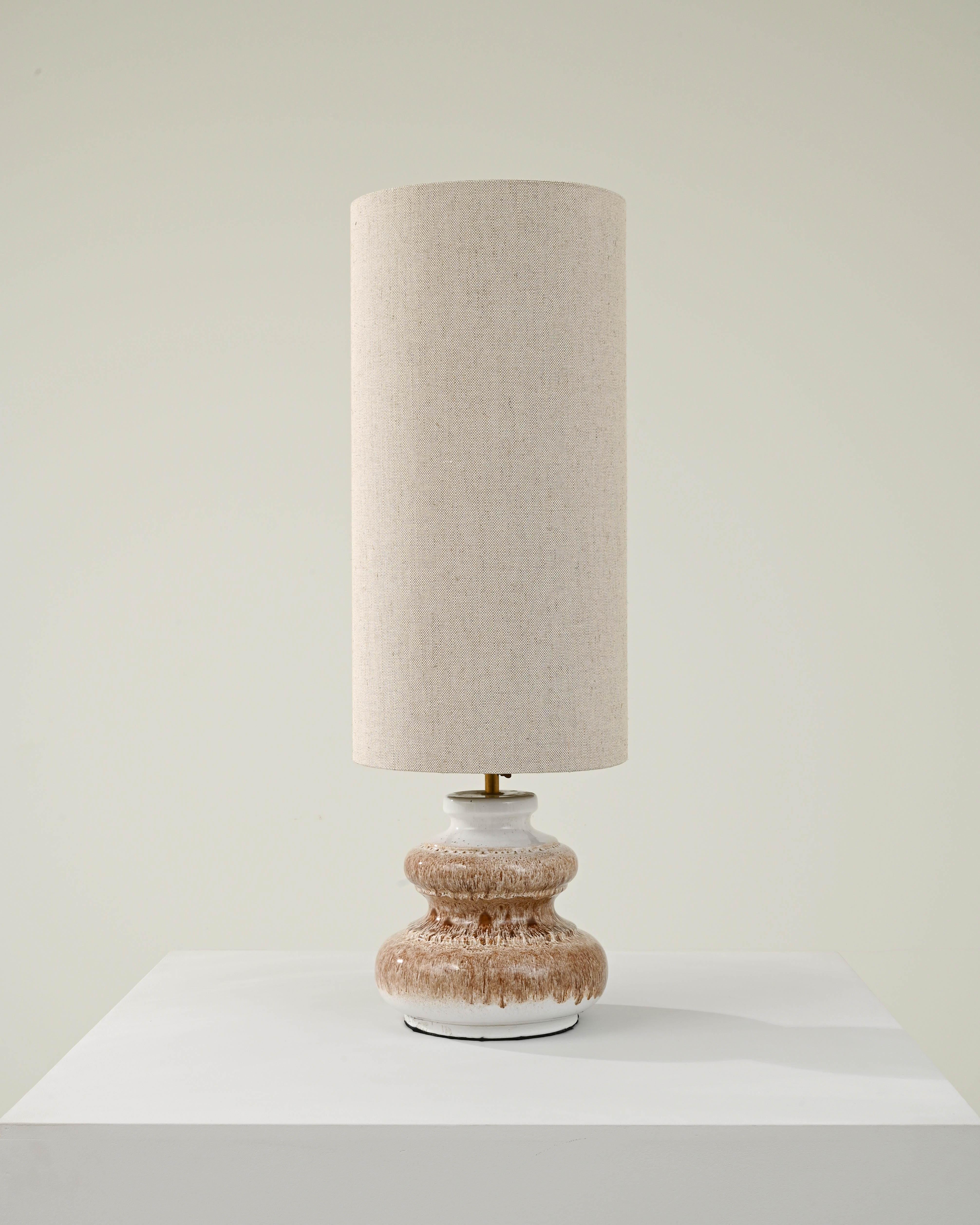 An exceptional find to inspire your collection. Designed in 1960s Germany, this distinctive vase has been adapted into a beautiful table lamp; the tall white lampshade is supported by a brass bulb socket. The fabric shade compliments the mottled