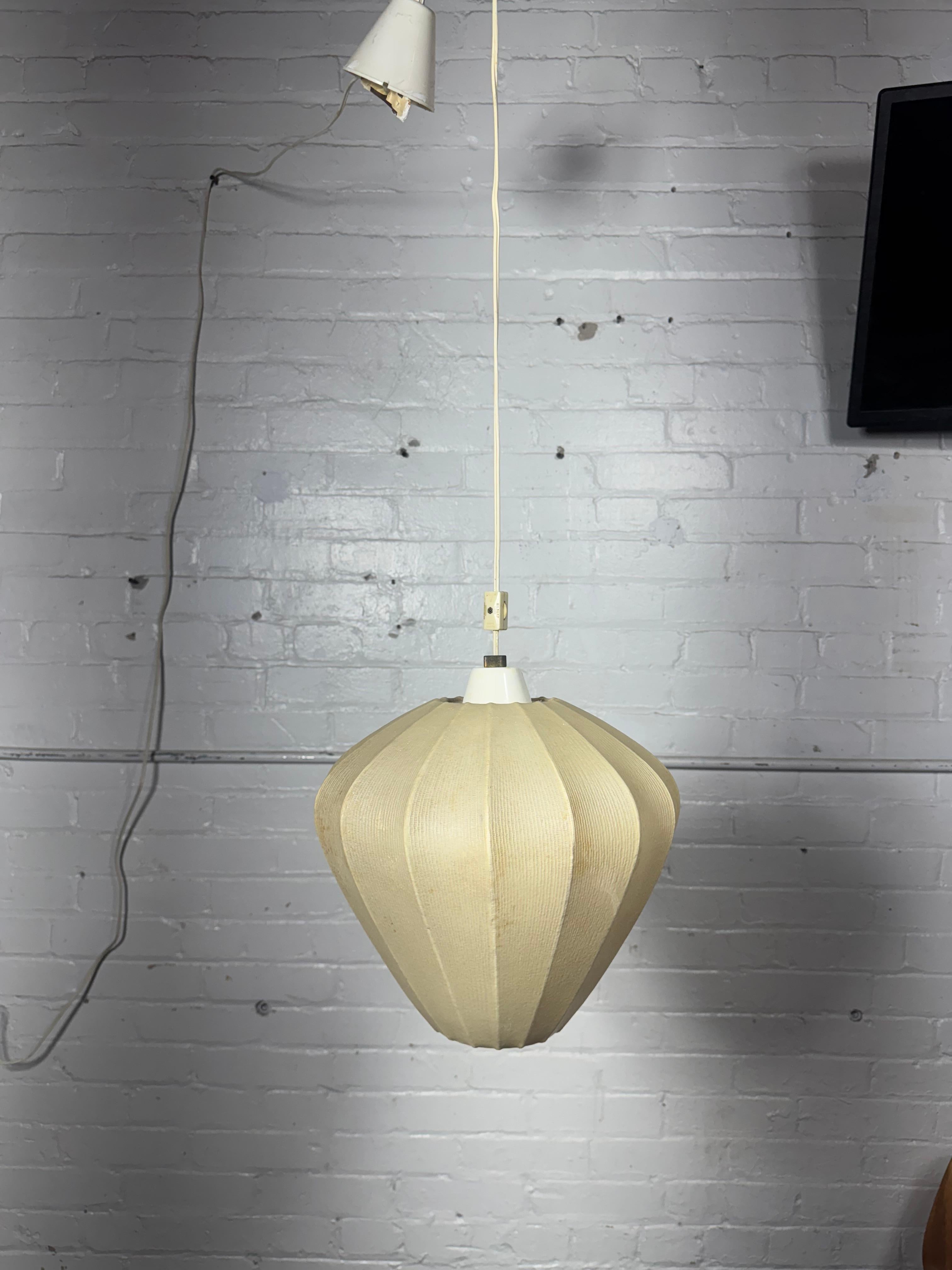 Seltene Mid Century Cocoon Pendelleuchte von Goldkant nach einem Entwurf von Friedel Wauer aus den 60er Jahren.

Der Cocoon-Schirm sorgt für diffuses, stimmungsvolles Licht. Gleichzeitig inszeniert sich der symmetrische Leuchtenkörper als imposantes