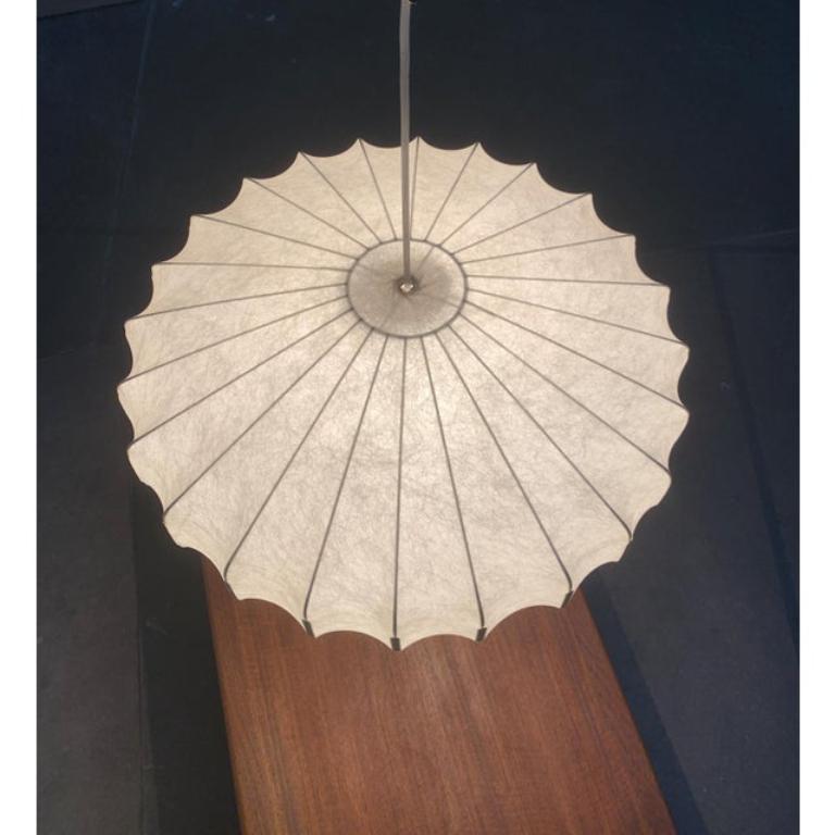 Rara lampada a sospensione Cocoon di Goldkant Lights, risalente alla metà del secolo scorso.

Lo schermo piatto a bozzolo fornisce una luce diffusa e d'atmosfera. Allo stesso tempo, il corpo simmetrico dell'apparecchio si presenta come un imponente