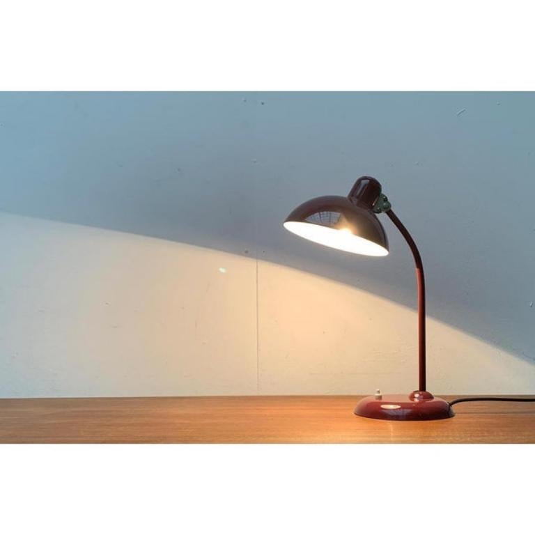 La lampada da tavolo classica di metà secolo di Kaiser rispecchiava un disegno di Christian Dell degli anni '30. Qui in una rara versione in tonalità rosso scuro.
 
 Un design molto semplice e funzionale. La classica luce da ufficio di un tempo. La