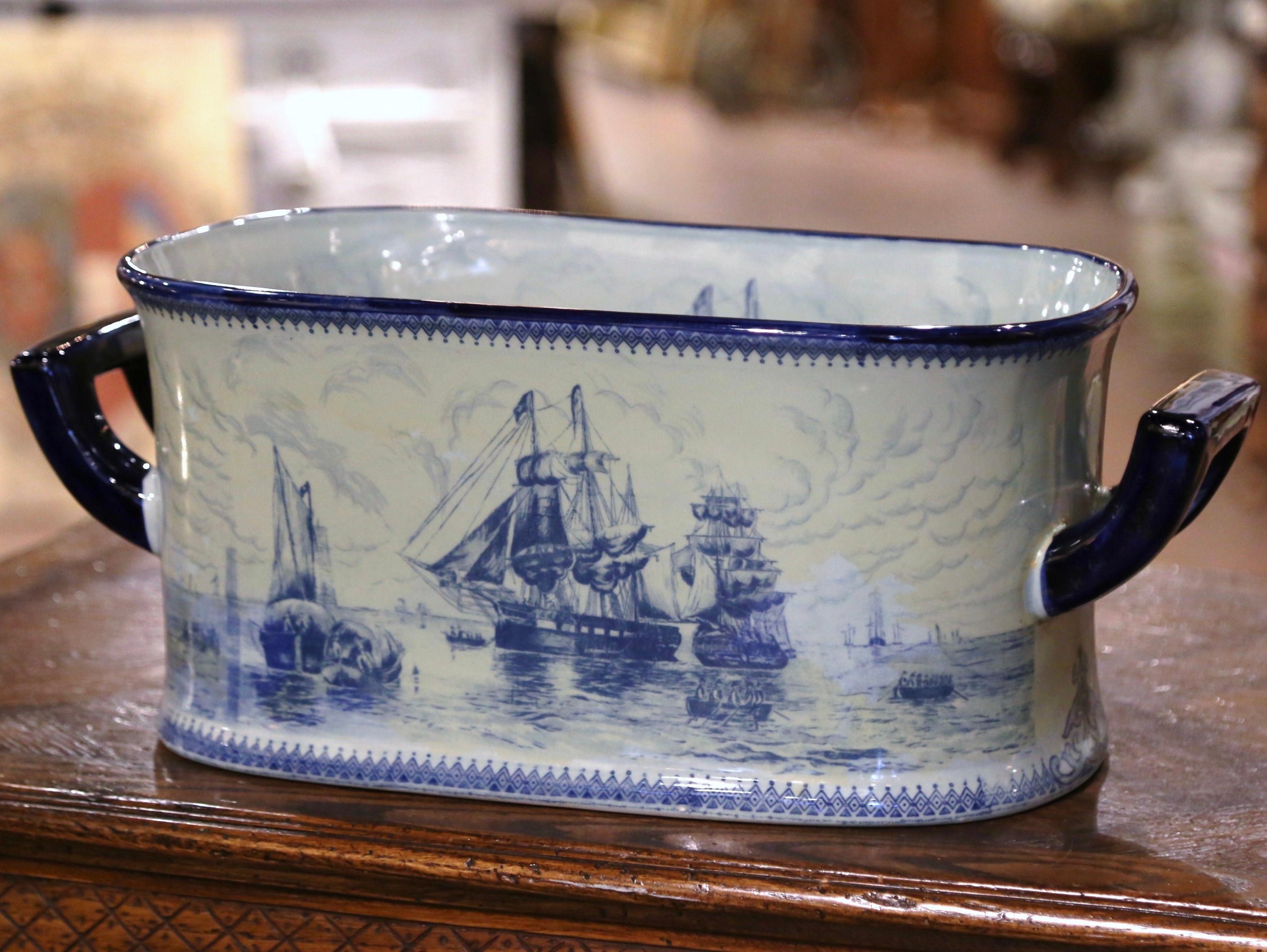 Esta gran maceta antigua fue fabricada por Meissen en Alemania hacia 1960. De forma oblonga, la jardinera de loza azul y blanca está adornada con fuertes asas azules y presenta escenas marinas pintadas a mano a la manera de Delft, con grandes