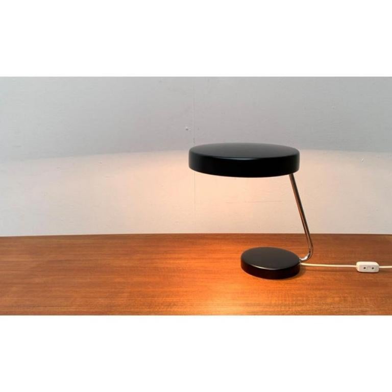 6658 table lamps by Kaiser glow in a rare color.

A minimalist design by Kaiser. The lamp convinces with its simple design language. The coloring in black and chrome supports this impression. The simple shape of the umbrella is particularly eye