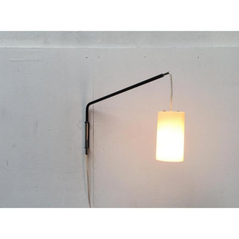 Lampada da parete minimalista di metà secolo con braccio girevole a sbalzo.

un design molto minimalista. Un paralume in plastica pende da un semplice e ampio braccio a sbalzo. Il braccio è angolato nella parte posteriore ed è montato in modo