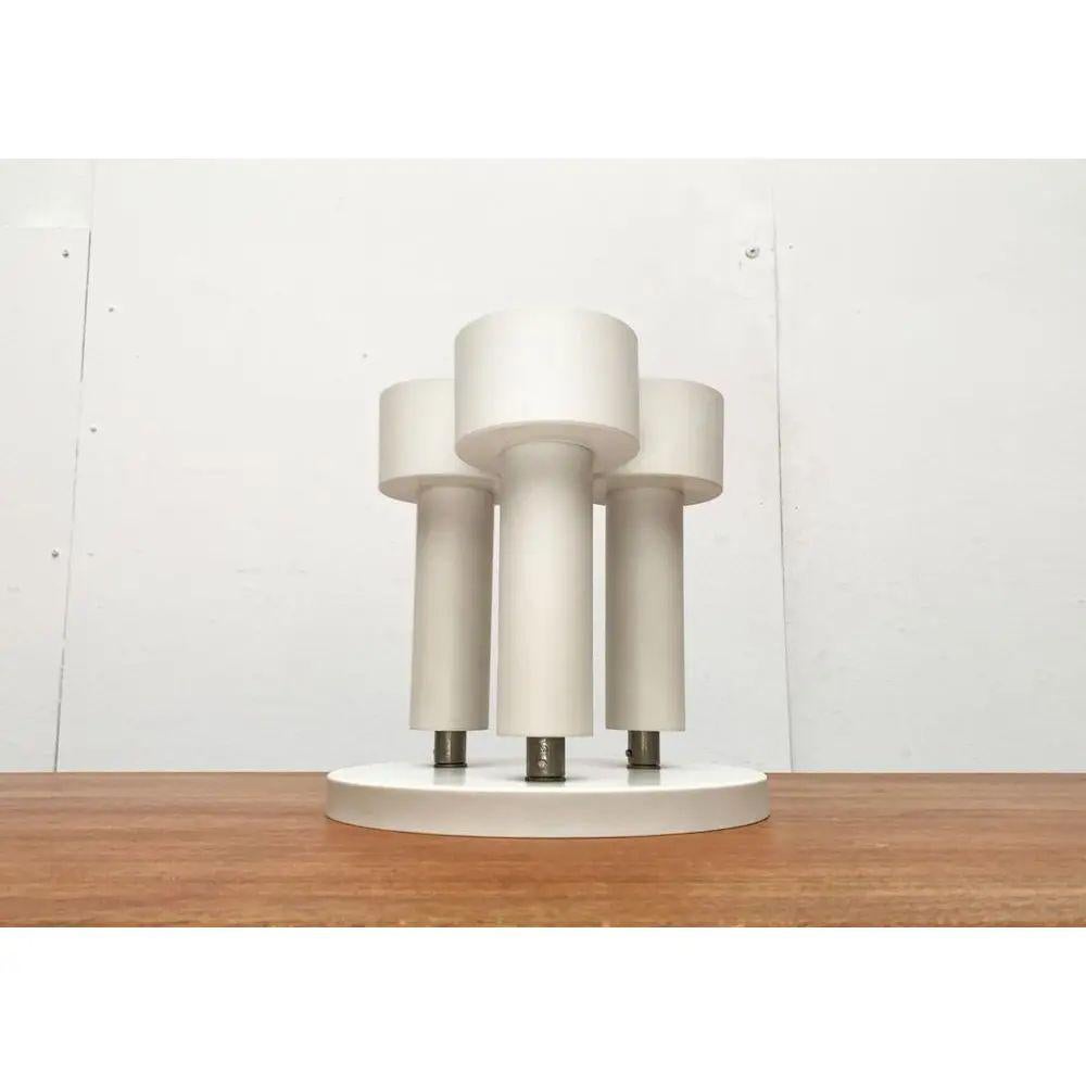 Minimalistische Mid-Century-Deckenleuchte von Beisl.

Die Leuchte besteht aus drei Stäben, die flexibel auf einer Baldachinplatte montiert sind. Auffallend ist die minimalistische Strahlungsform der weißen Lichtköpfe. Einfacher Zylinder in