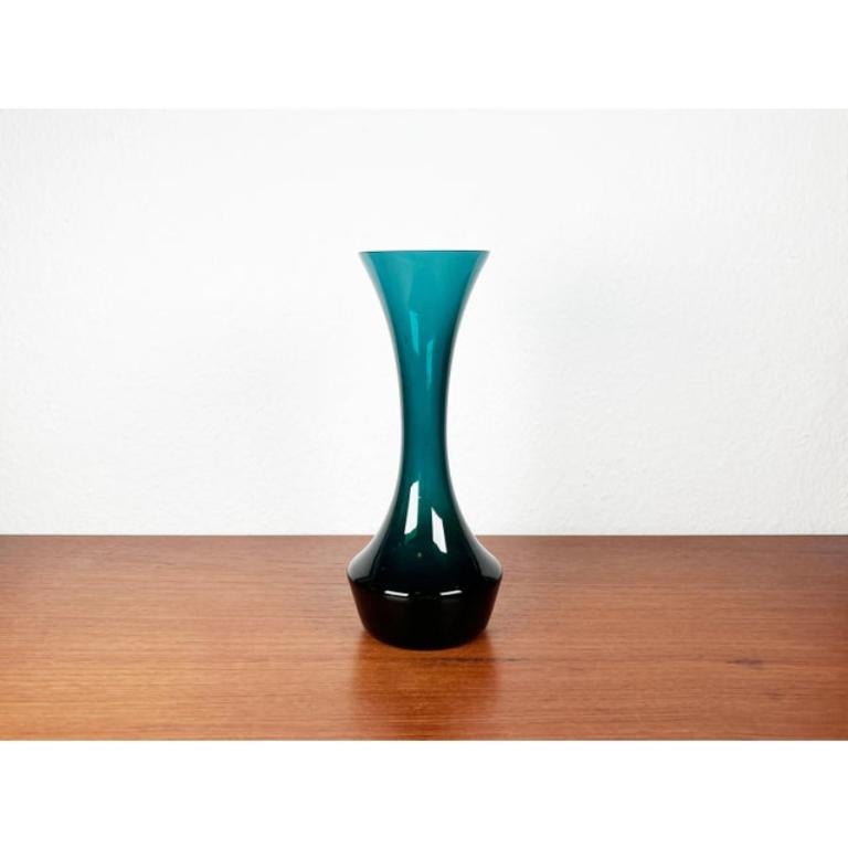 Deutsche minimalistische Vase aus grünem Glas aus der Jahrhundertmitte, 1960er Jahre, in sehr gutem Zustand. Entworfen 1960 bis 1969

Zusätzliche Informationen:
MATERIALIEN: Glas
Farbe: Blau
Stil: Moderne Mitte des Jahrhunderts
Zeitraum: