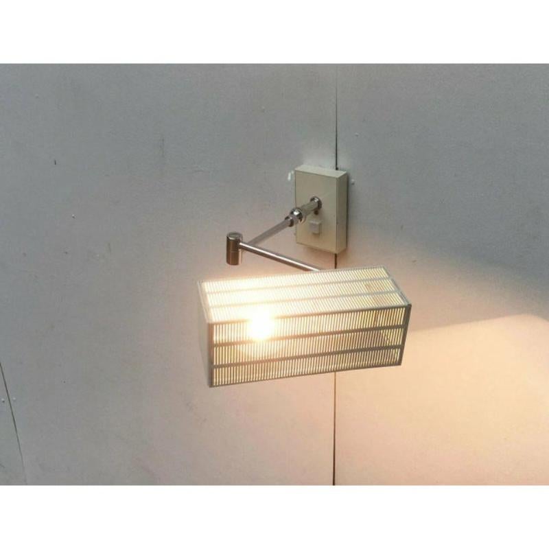 Lámpara de pared de mediados de siglo del fabricante alemán Bur Leuchten. Una rara variación del flamenco como aplique blanco.

Las formas cúbicas impregnan este diseño, desde la pantalla hasta detalles como el interruptor o la placa de pared. El
