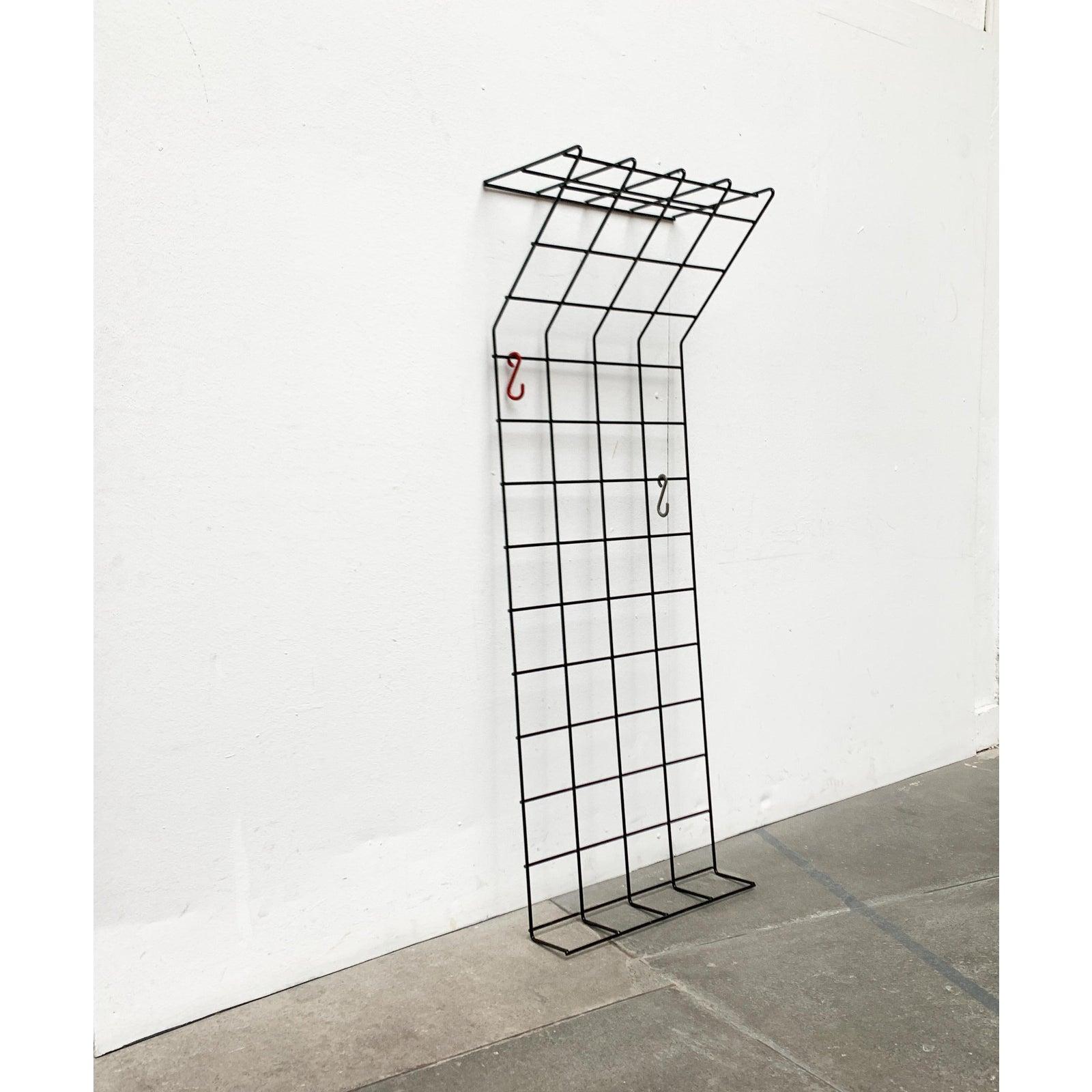 Black Mid Century lattice coat rack in a particularly narrow version.

Simple coat rack made of coated metal lattice. The upper and lower parts are shaped into a shelf. The two original hooks can be moved as needed. No hooks included. 

Additional