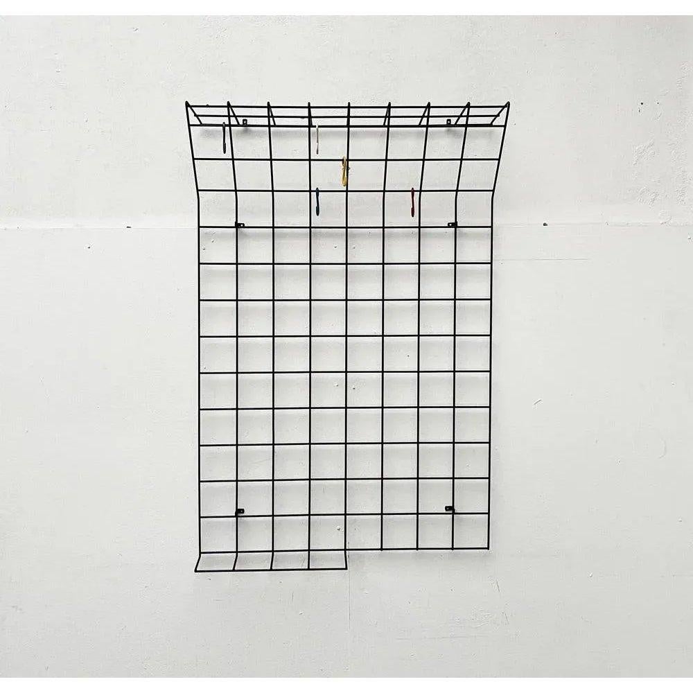 Gitterwarderobe minimalista di metà secolo.
Armadio semplice con griglia in metallo Coates. La parte superiore e parte di quella inferiore hanno la forma di un ripiano. L'armadio viene installato con angoli integrati a distanza dalla parete. I ganci