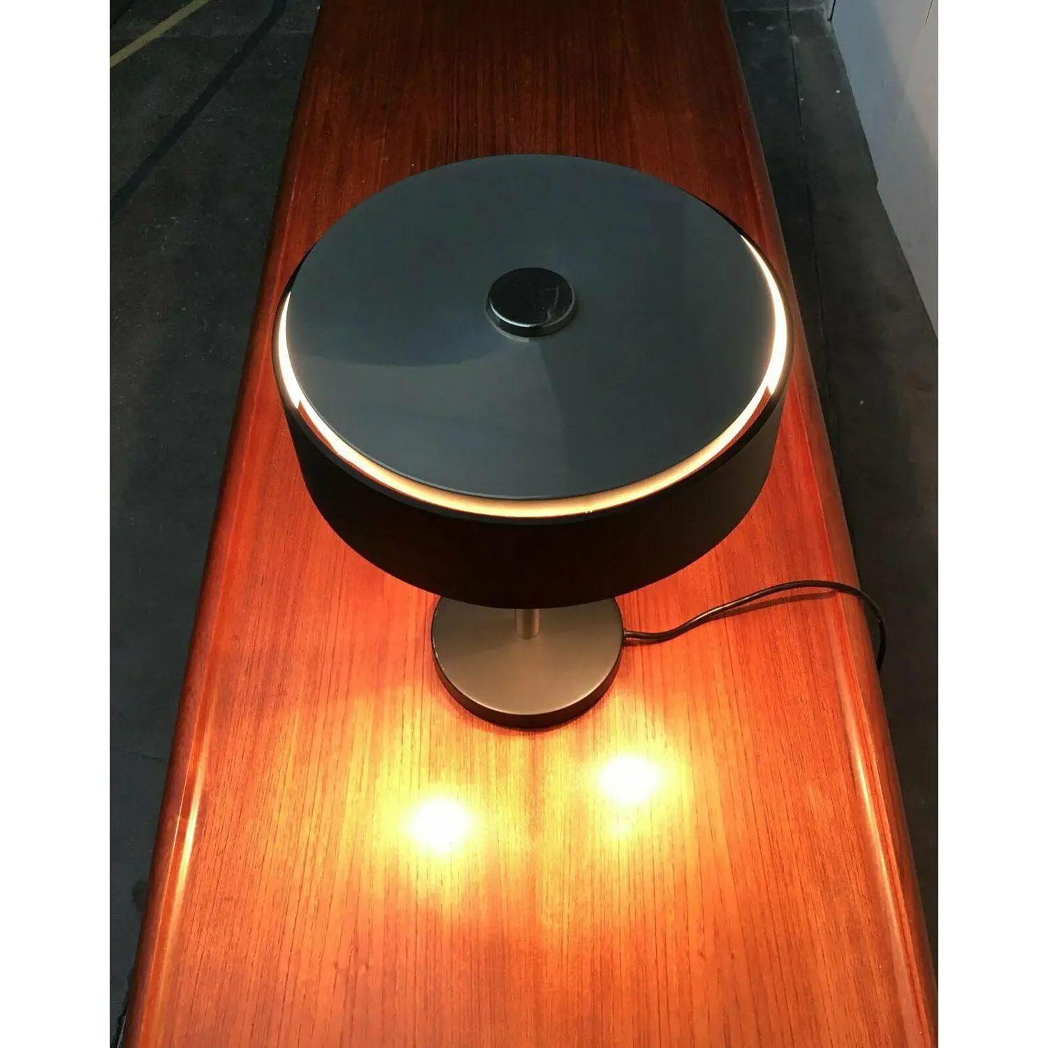 Rare mid-century table lamp from Hillebrand.

A very straightforward design with a clear design language. The color scheme in chrome and black supports this. The shade is a flat cylinder, the base is a simple plate. Both are connected via a