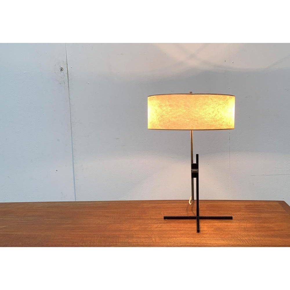 Very rare Mid Century table lamp by Kaiser lights with a special minimalist foot.

The special detail of this luminaire is the simple, black star foot from square rods, which is hard to exceed simplicity and simple elegance. Another detail is the