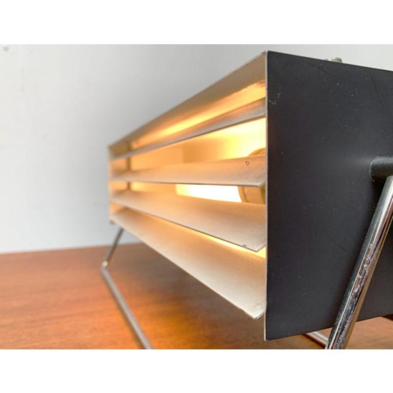 Minimalist table lights from Kinkeldey.

The design convinces with its cubic design language. The lamp consists of a dark gray-painted, cuboid -shaped body, which is upset via a finely designed chrome frame. The front of the simple metal housing is