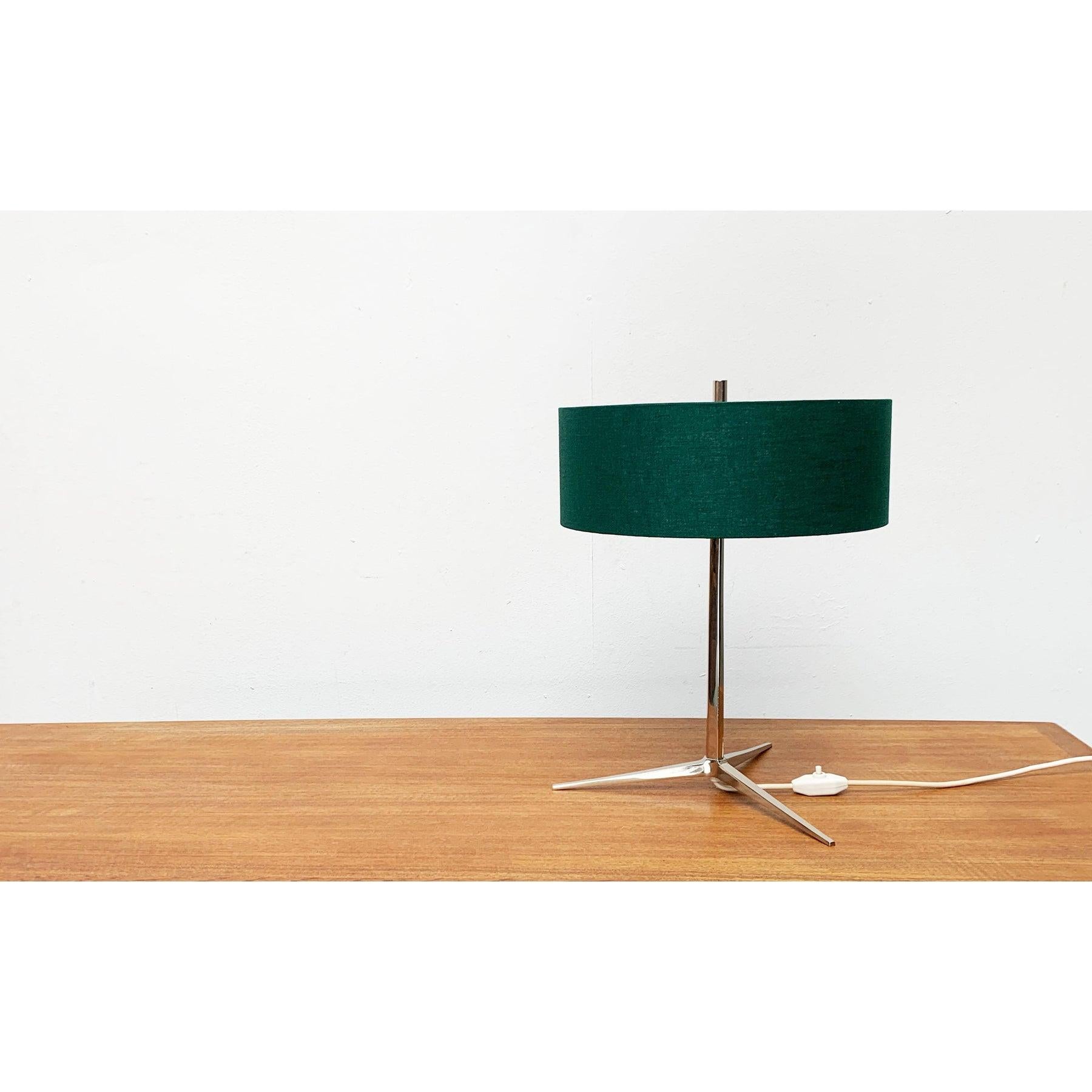 Very rare Mid Century table lamp from Kaiser Leuchten with a special tripod base.

A minimalist design. The most distinctive detail of this lamp is the elegant tripod base in chrome. The stem branches out at the bottom to form a tripod. The feet