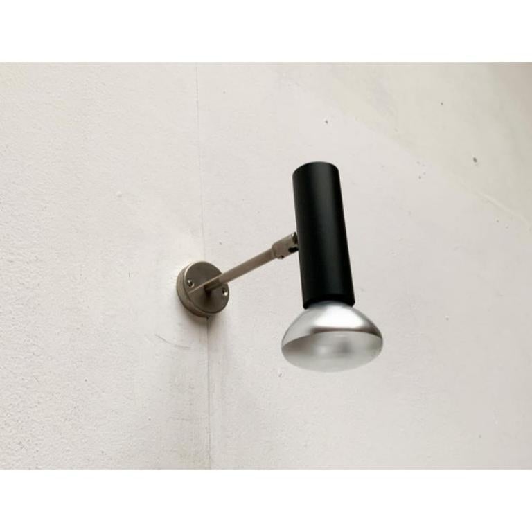 Lampada da parete minimalista di metà secolo di Beisl.

La forma cilindrica minimalista della testa della luce nera è sorprendente. La testa si trova all'estremità di un braccio dotato di uno snodo alle estremità anteriori. In questo modo, la testa