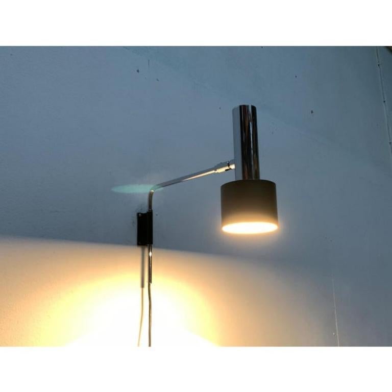 Lampada da parete del Mid Century di Cosack in cromo e nero.

Un design minimalista. Il corpo illuminante presenta una semplice forma radiante con elementi cilindrici. Can può essere allineato individualmente tramite un giunto. Il braccio semplice,