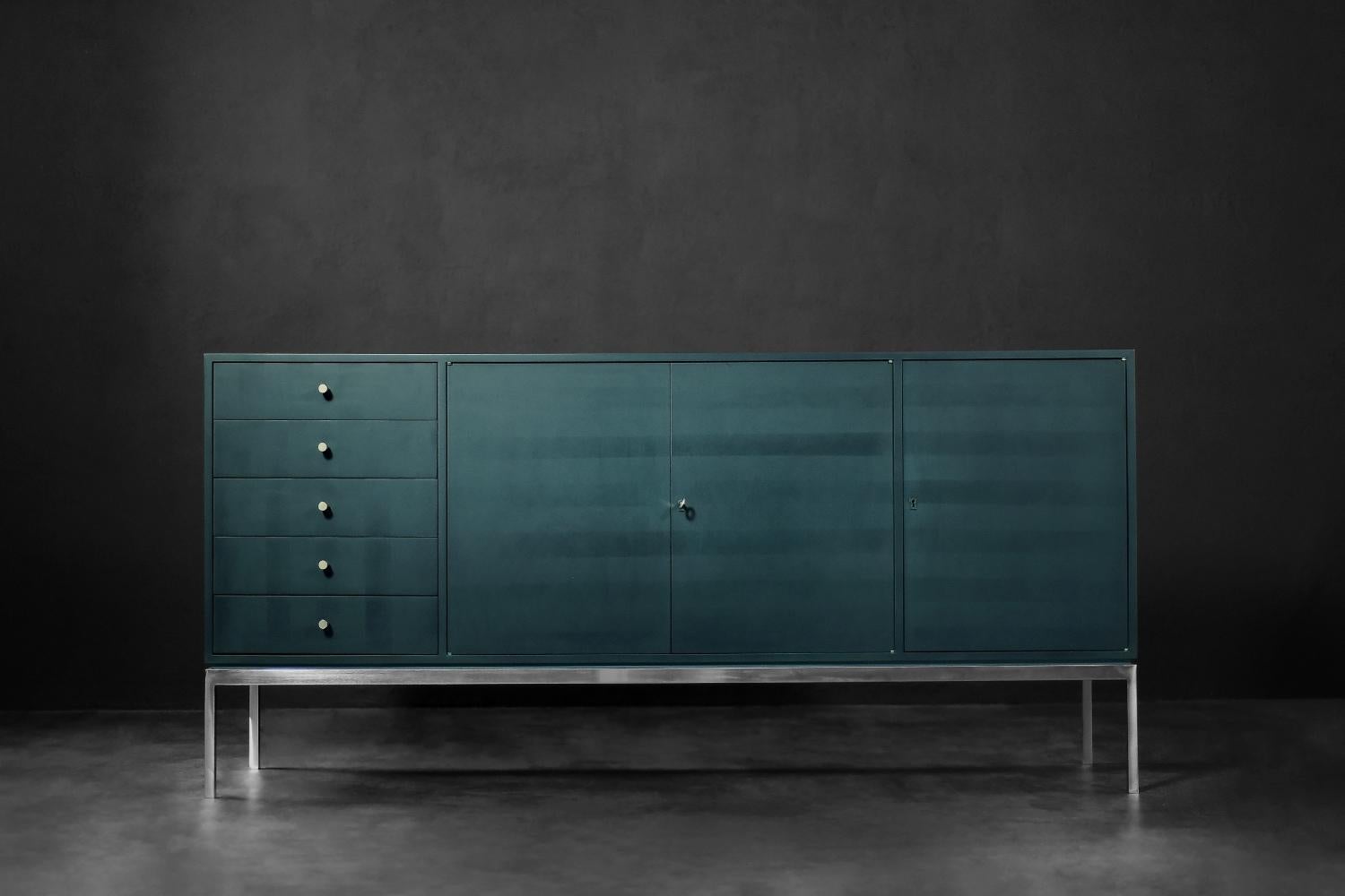 This tall sideboard was made in Germany during the 1970s. It has five drawers and two lockable cabinets with shelves. The base is a rectangular, chrome-plated frame. The cabinet combines high functionality and original appearance. It was covered