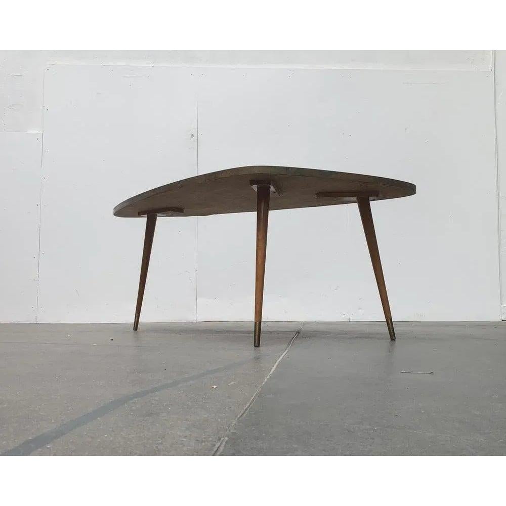 Mesa de centro de mosaico de Berthold Müller-Oerlinghausen de los años 60.

La mesa tiene una forma básica triangular con esquinas redondeadas. Las patas de madera maciza concluyen con pies de latón en la parte inferior. La peculiaridad de esta mesa