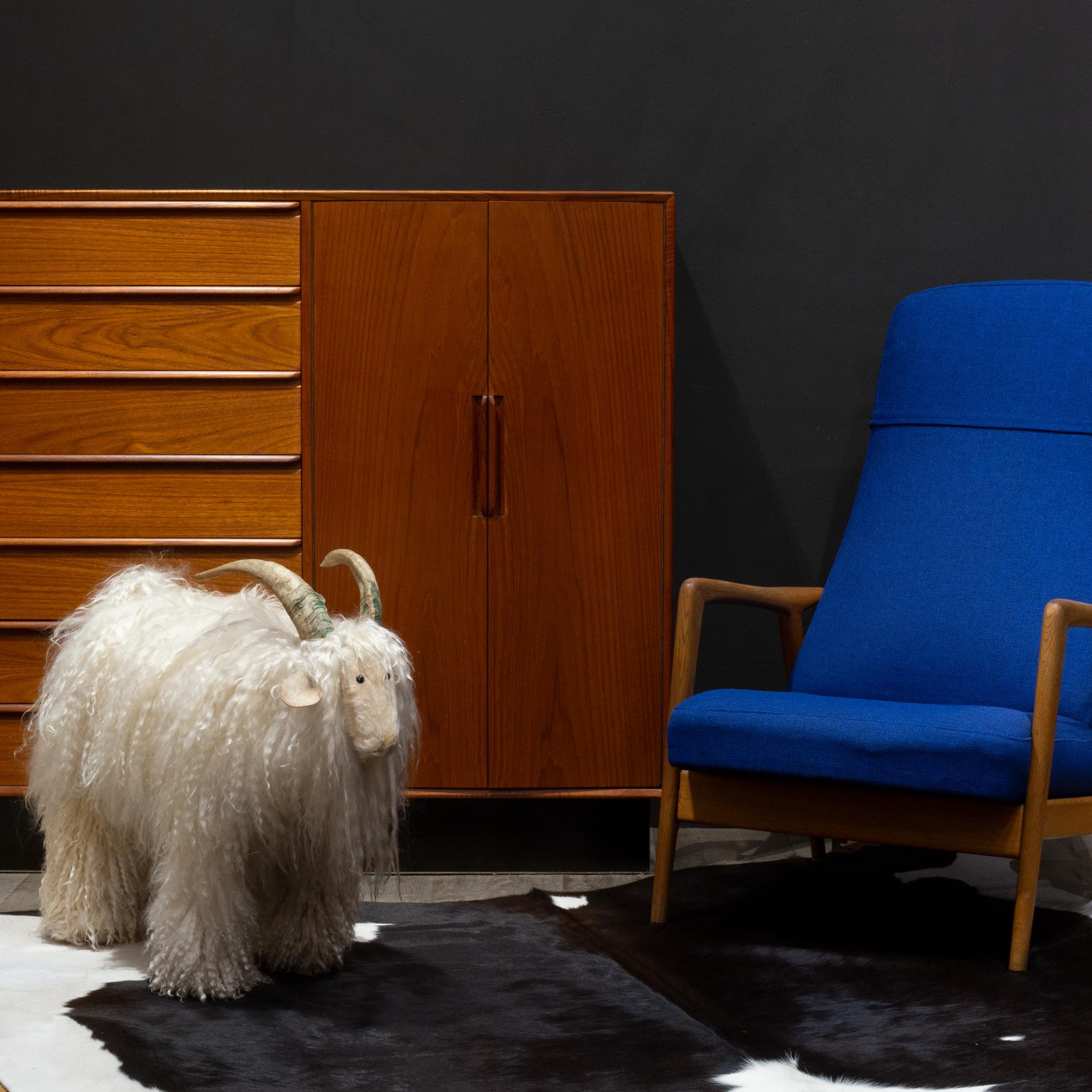 ABOUT

Vintage Mountain Goat footstool made with Lambswool or Mohair wool, leather ears and natural horns, circa 1960s. The face and hooves are covered in short, soft wool. Made in Germany. Very soft.

    CREATOR Unknown.
    DATE OF MANUFACTURE