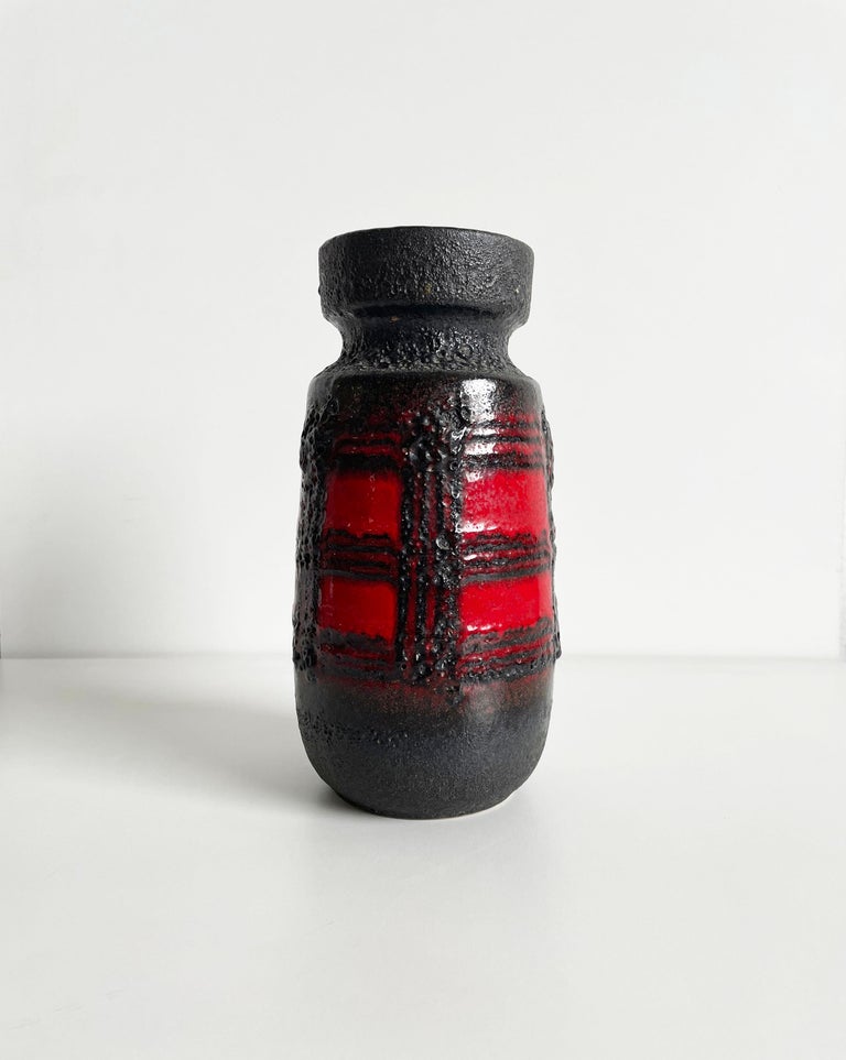 This vase 242-22 was produced in the 1960s in West Germany by Scheurich. It's made of ceramics using the fat lava technique.
The vibrant red glaze is covered in black geometrical fat lava decoration.

Dimensions: 22.8 x 12 x 12 cm