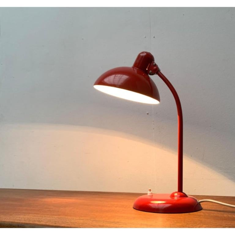 Classic mid century table lamp from Kaiser Leuchten after a design by Christian Dell from the 1930s. Here in a rare version in a strong red tone.

A very simple and functional design. The classic office light from back then. The lamp can be