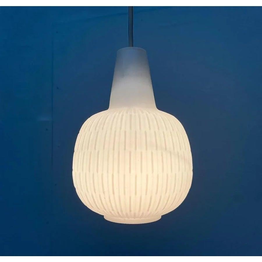 Lampada a sospensione in vetro di metà secolo del rinomato produttore Peill & Putzler su disegno di Aloy's Gangkofner degli anni '50.

Un design classico. L'elegante corpo della lampada in vetro è opalino e decorato con un motivo regolare e sublime