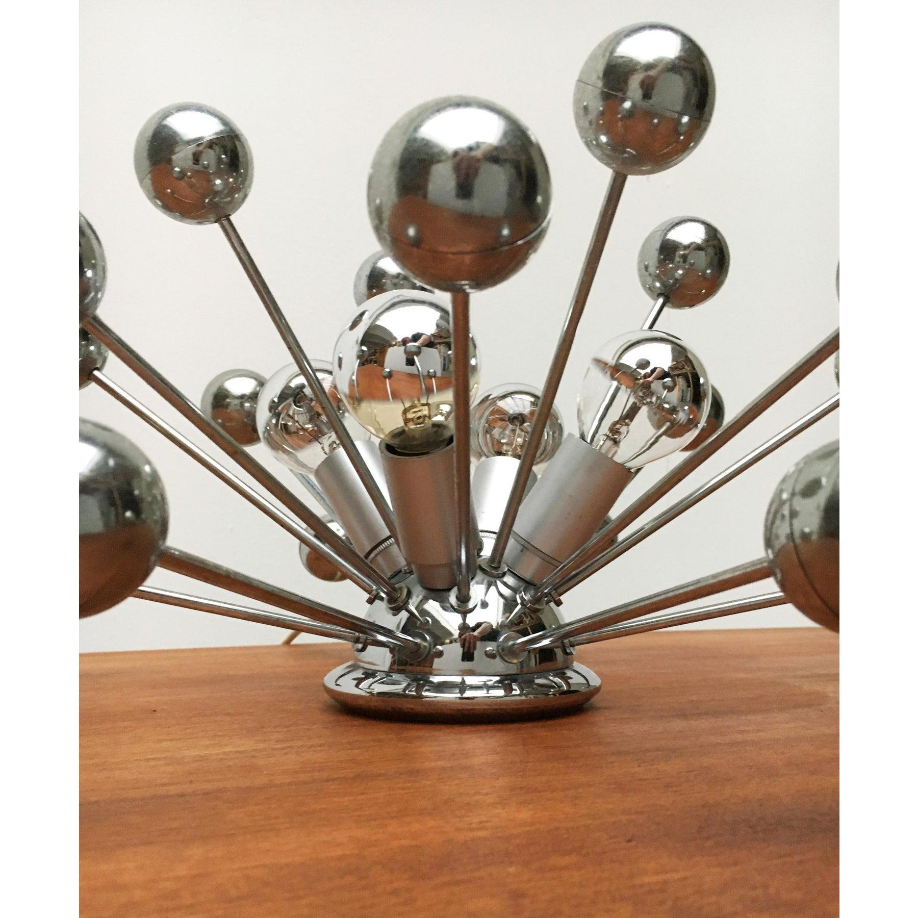 Rare lampe de table atomique de Cosack datant de l'ère spatiale.

Un design vraiment impressionnant. À partir d'un hémisphère central, quatre brûleurs dépassent du luminaire. Entre les boules chromées dans une variété de barres fines. Des lampes et