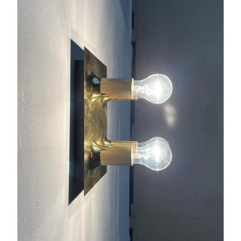 Aplique o plafón de la Era Espacial de Cosack con superficie de latón espejado.

La lámpara tiene cuatro puntos focales que se asoman a la placa formando una cuadrícula. Los cilindros con las versiones sobresalen suavemente de la placa base. Al
