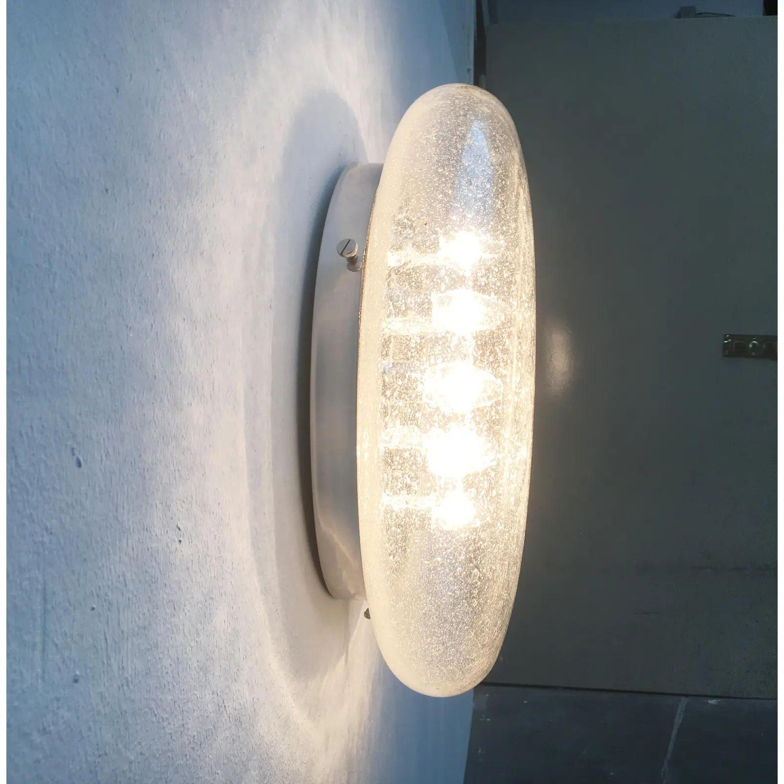 Imponente lampada da soffitto o da parete dell'era spaziale.

Questo design convince per le sue dimensioni imponenti e le sue superfici riflettenti. Il gioco di riflessi crea una profondità speciale. Le superfici riflettenti raddoppiano gli elementi