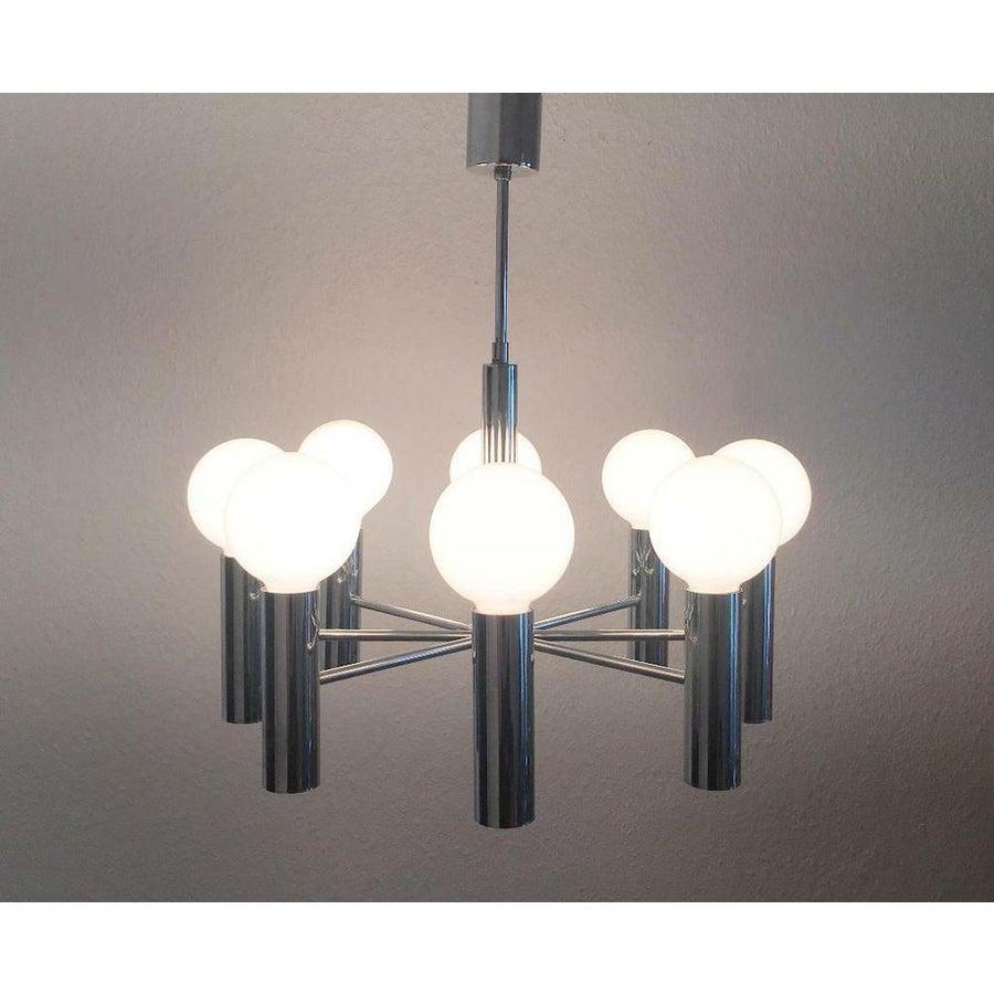 Imponente candeliere dell'era spaziale del produttore tedesco di luci Hustadt.

Questo candeliere combina un linguaggio di design minimalista e concreto con l'imponenza di un lampadario classico.
Da un cilindro centrale al centro, altri 8 cilindri