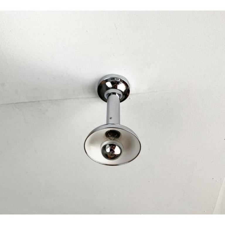Plafoniera NO AGE di Cosack.

La lampada è completamente realizzata in cromo. Il corpo luminoso è costituito da un lungo cilindro che si allarga fino a diventare un ombrello e un baldacchino. La lampada si monta sul soffitto con una staffa. È