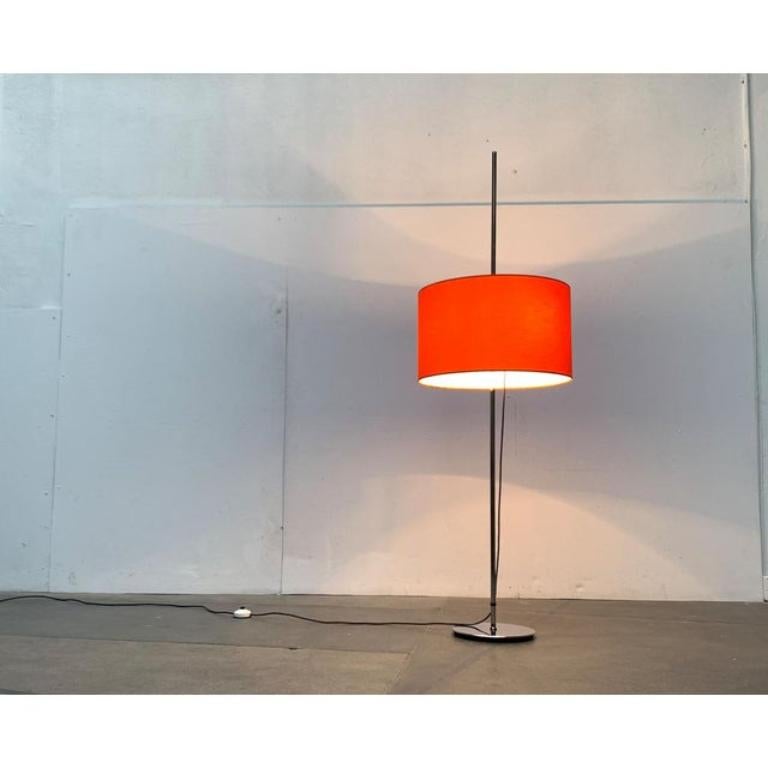 Semplici lampade da terra della metà del secolo scorso di Staff shine.

Il paralume ha una classica forma a tamburo ed è ricoperto di arancione. Può essere fissata liberamente sull'asta cromata dell'albero in altezza, il che conferisce alla lampada