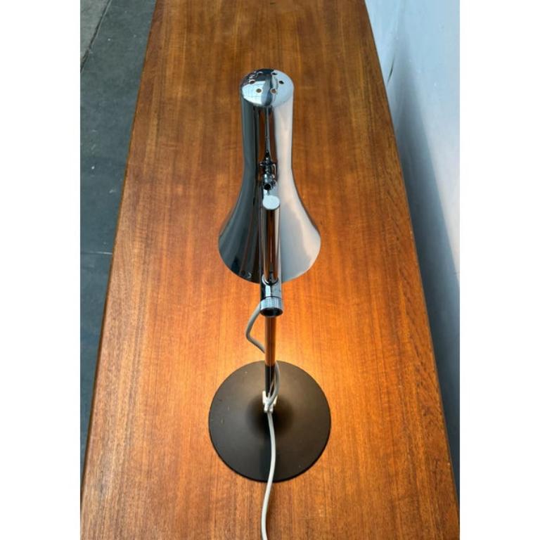 Lampe de table du milieu du siècle dernier du fabricant allemand Hillebrand.

Le parapluie étroit du sac, avec sa surface polie, est un détail frappant. La tête de la lampe peut être déplacée vers le haut et vers le bas sur l'arbre, et l'abat-jour