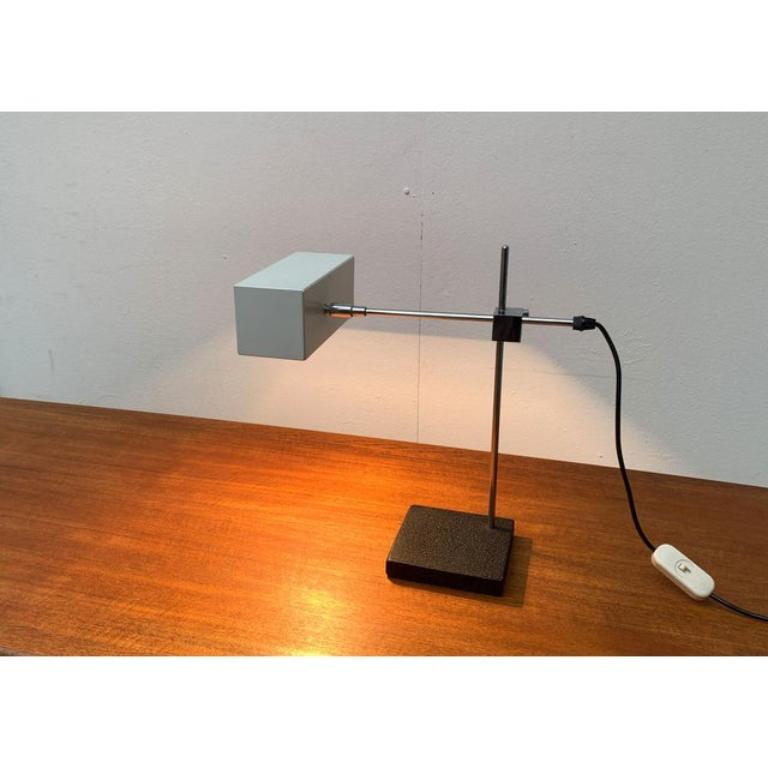 Lampe de table du milieu du siècle de Max Bankenholz. Ici dans la version avec le parapluie blanc. La lampe est presque identique à la lampe de table flamant rose du fabricant allemand Bur Leuchten.

Des formes cubiques parcourent ce dessin, du