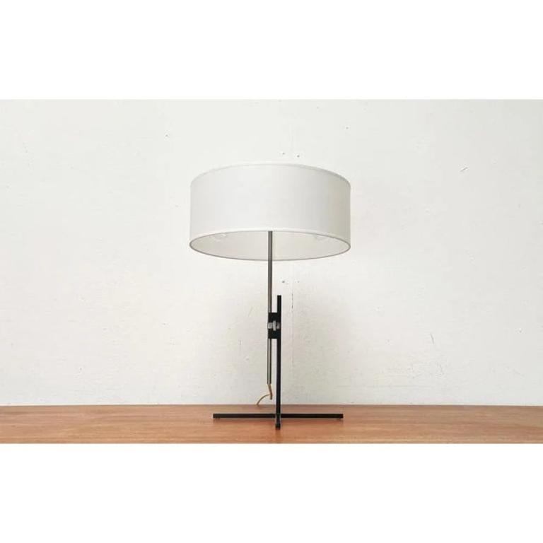 Rara lámpara de sobremesa de mediados de siglo de Kaiser glow con un pie minimalista especial.

El detalle especial de esta lámpara es el sencillo pie de estrella negro hecho de varillas cuadradas, difícil de superar en cuanto a sencillez y
